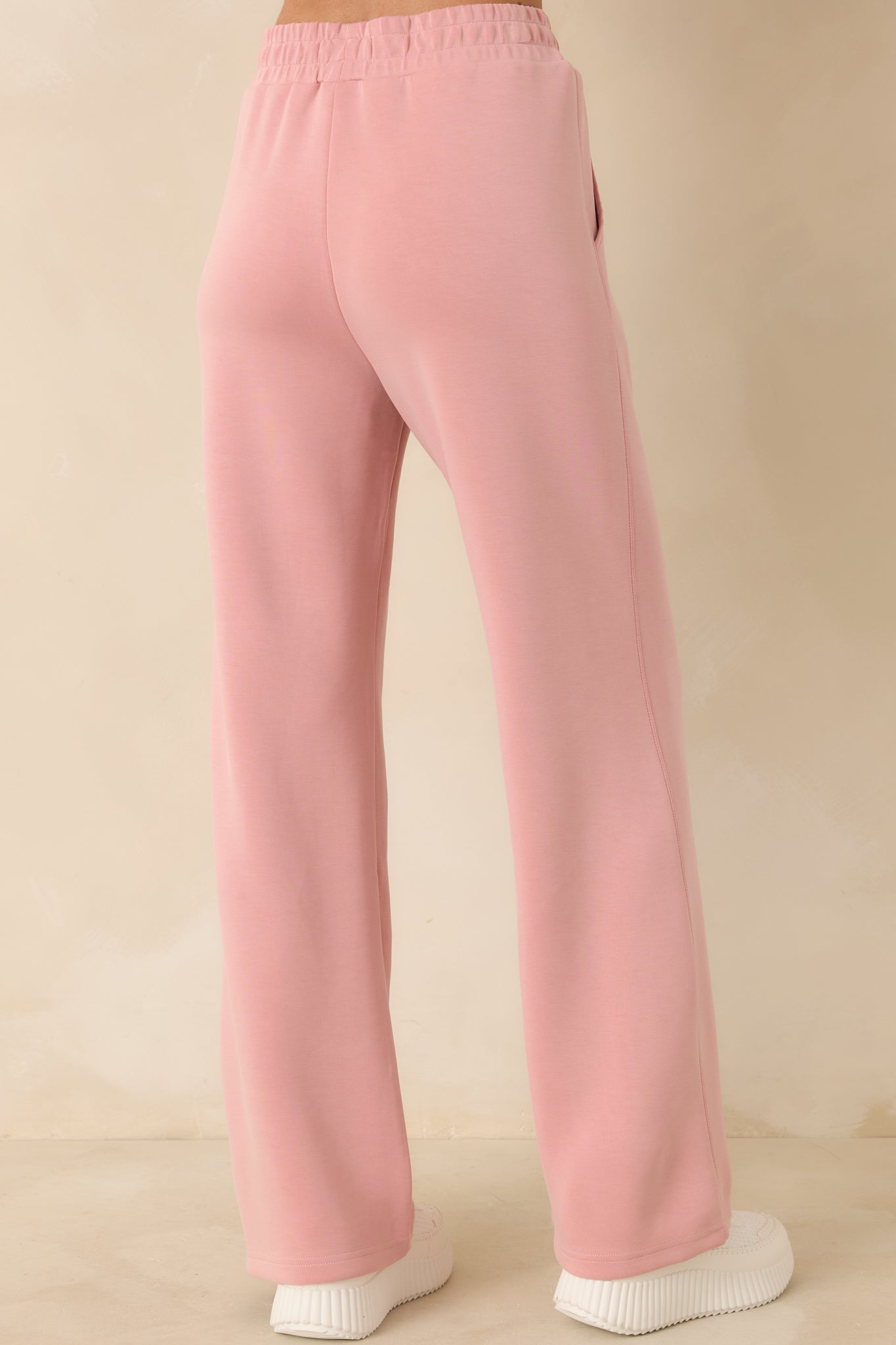 Rear view of powder pink sweatpants showing wide-leg silhouette and relaxed fit.