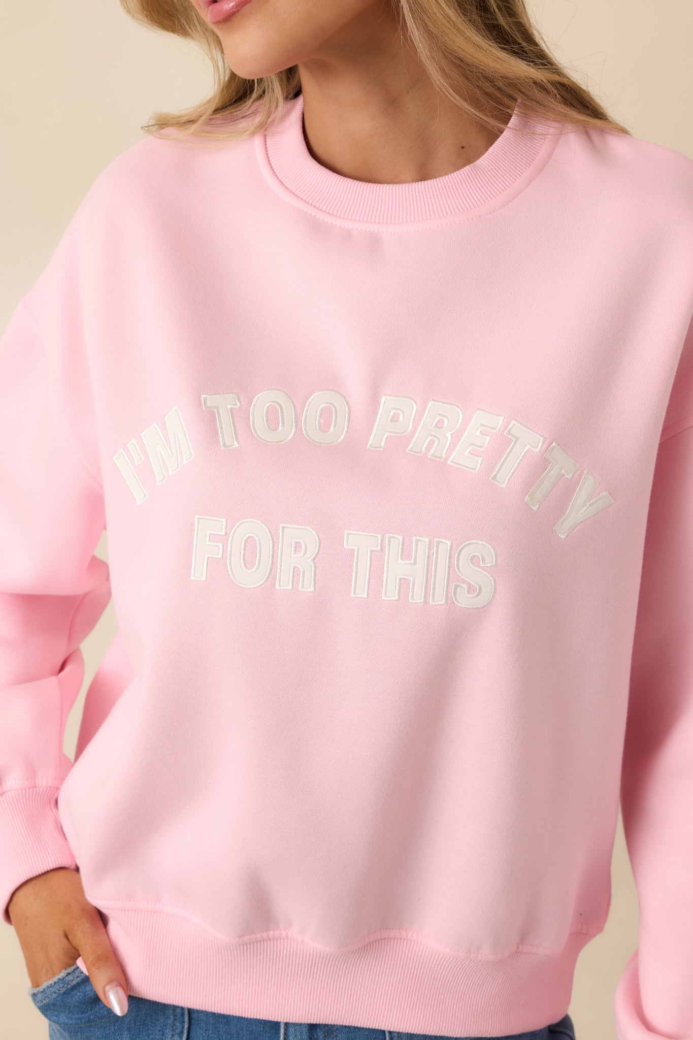 Ribbed cuff trim on a pink sweatshirt showing textured knit detail and clean stitching.