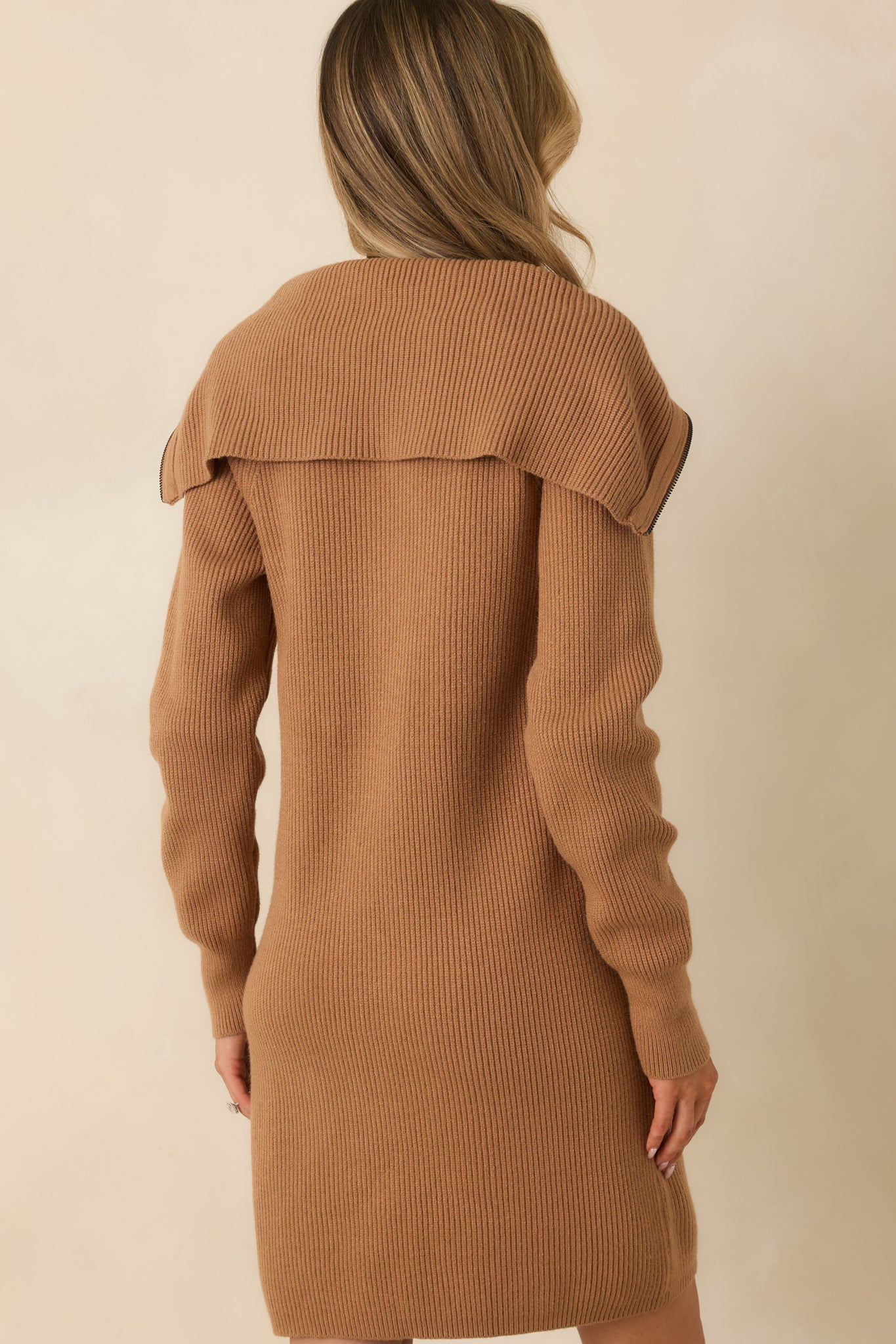 Rear view of camel sweater dress showing straight hemline and relaxed longline fit.