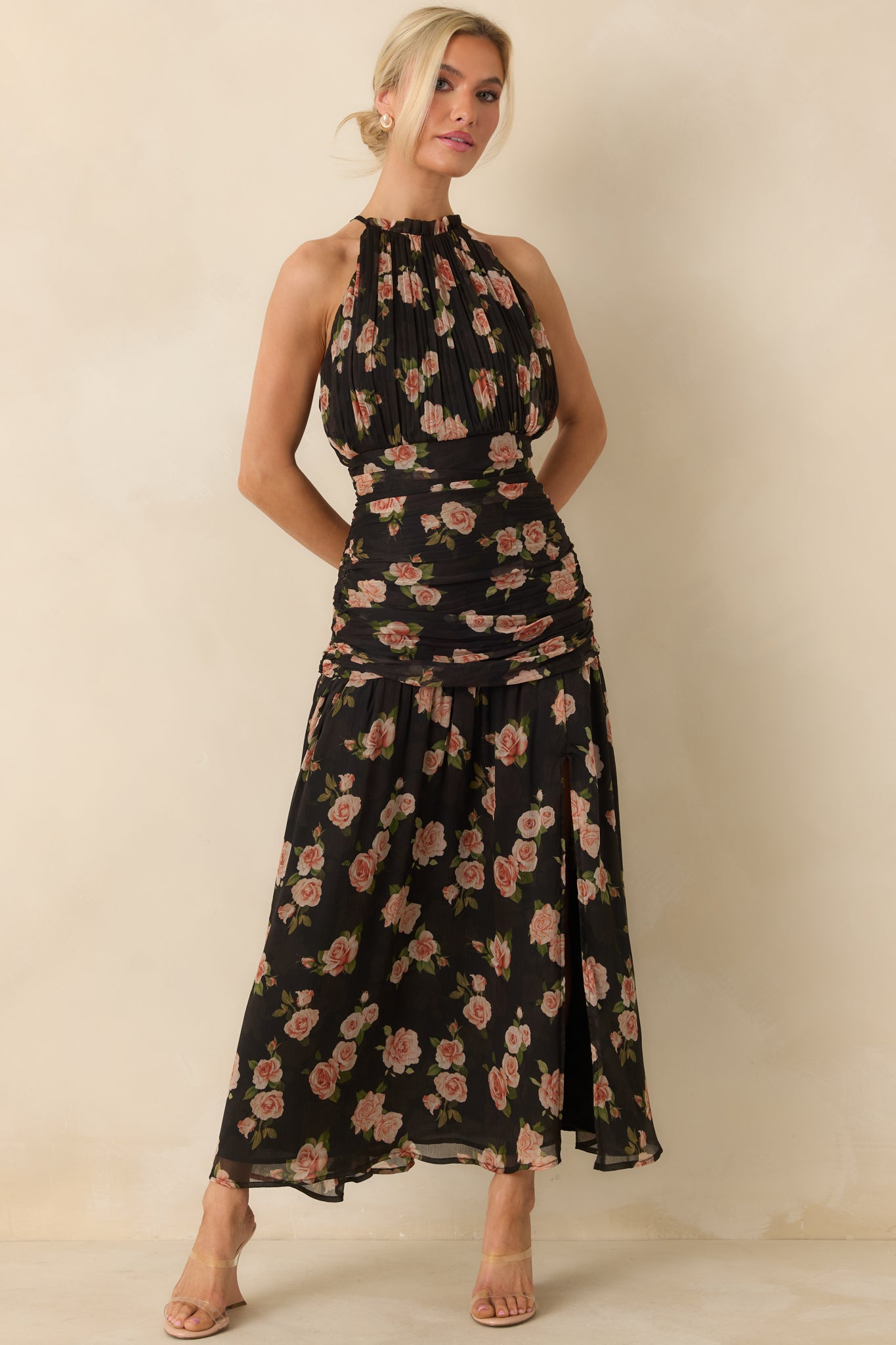 Halter-neck black chiffon maxi dress with a delicate blush and green floral pattern across airy chiffon fabric.
