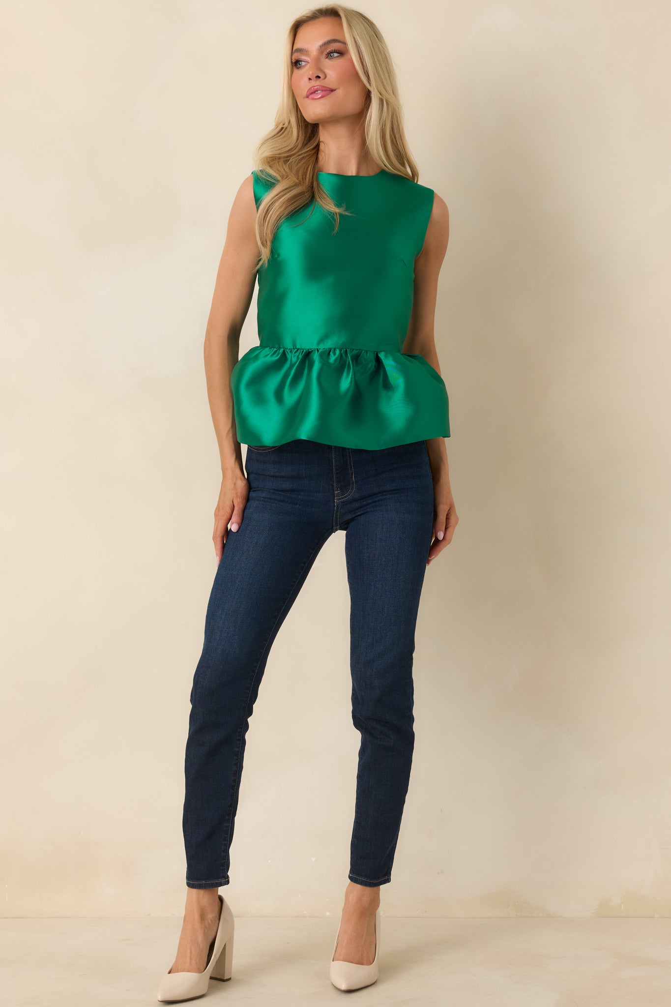 Emerald green top highlighting the crisp woven texture and elegant peplum shape.