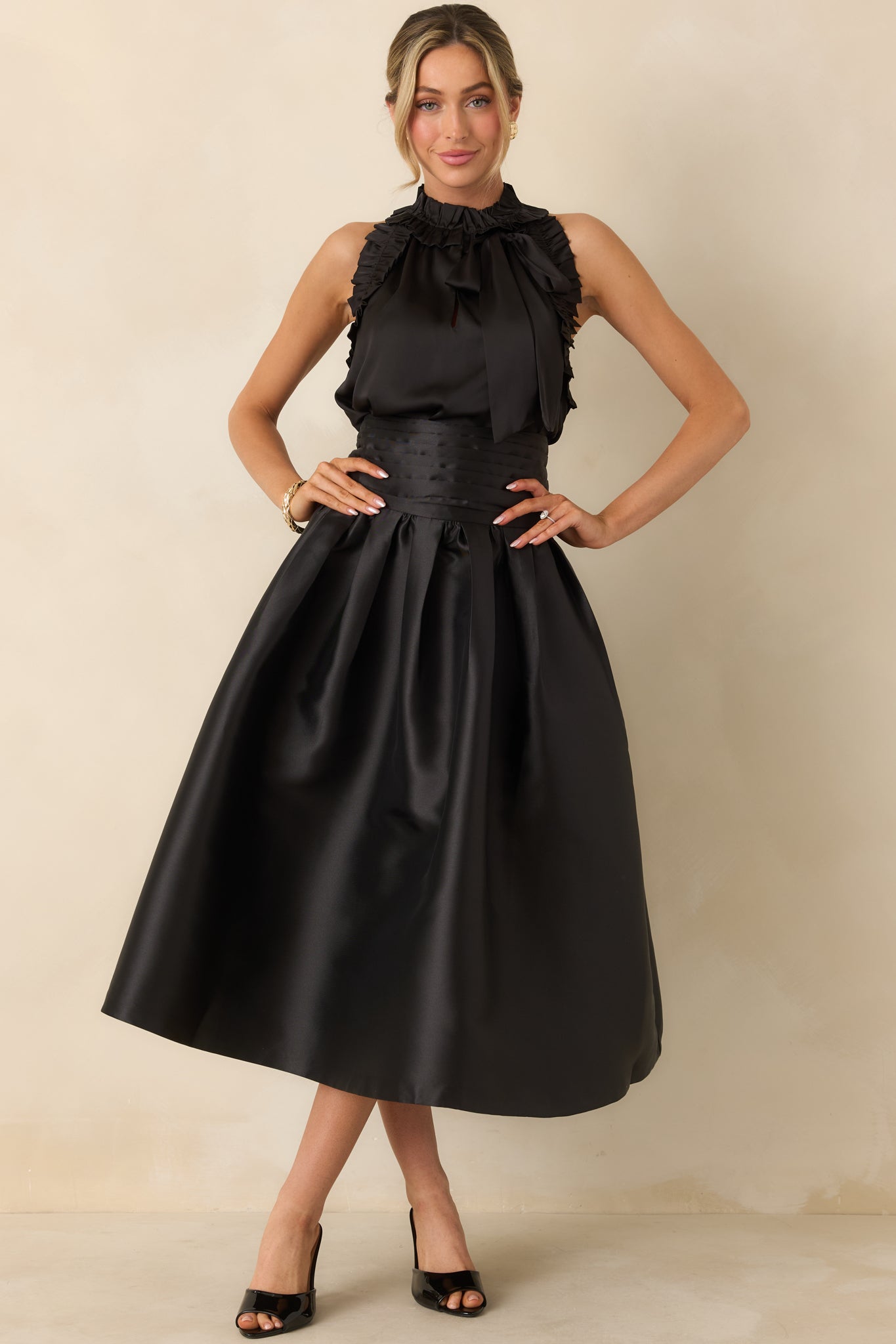 Pleated black maxi skirt highlighting the smooth waistband and flowing A-line shape.