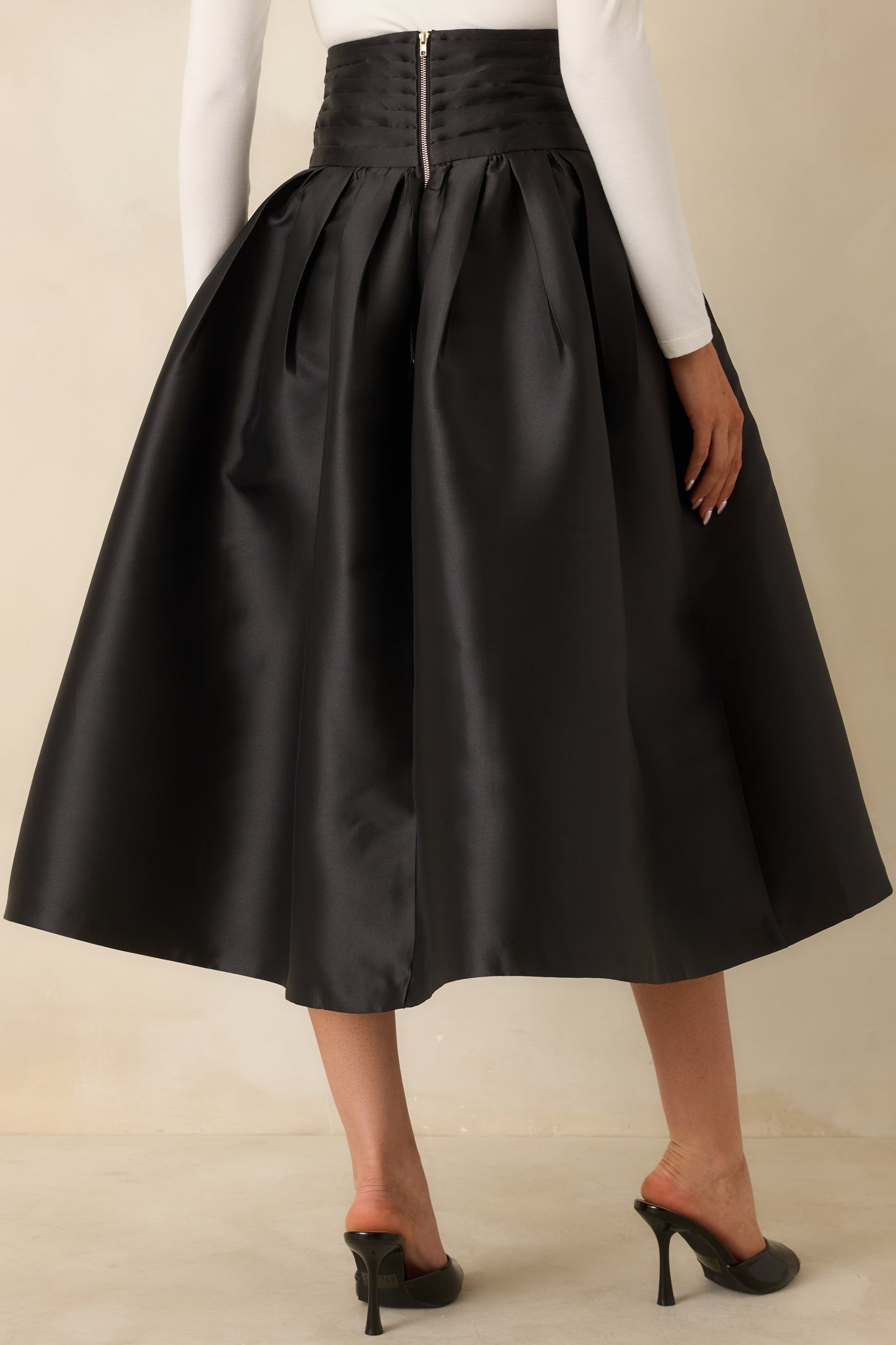 Rear view of the black maxi skirt featuring the exposed back zipper closure and pleated volume.