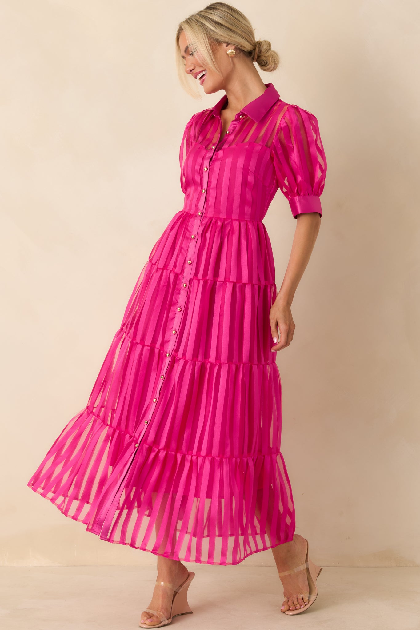 Fuchsia maxi dress with cuffed puff sleeves, collared button-front bodice, and flowing tiered skirt for gentle movement.