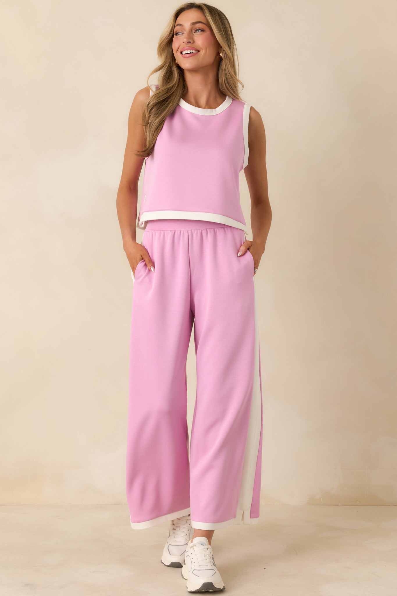 Soft orchid pink wide-leg knit pants featuring an elastic waistband and bold contrast hem accents.