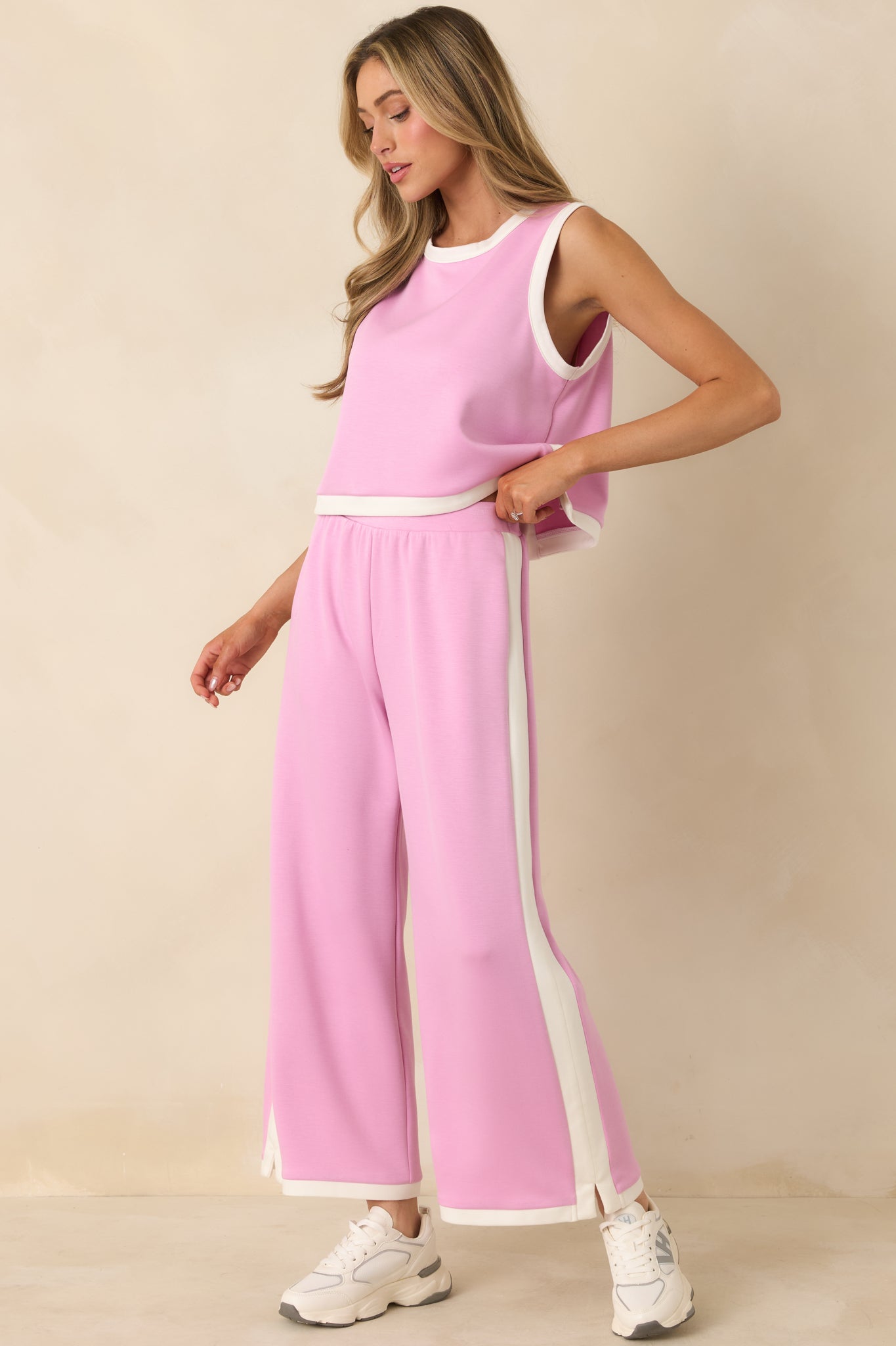 Relaxed orchid pink knit pants with clean contrast trim running the length of both side seams.