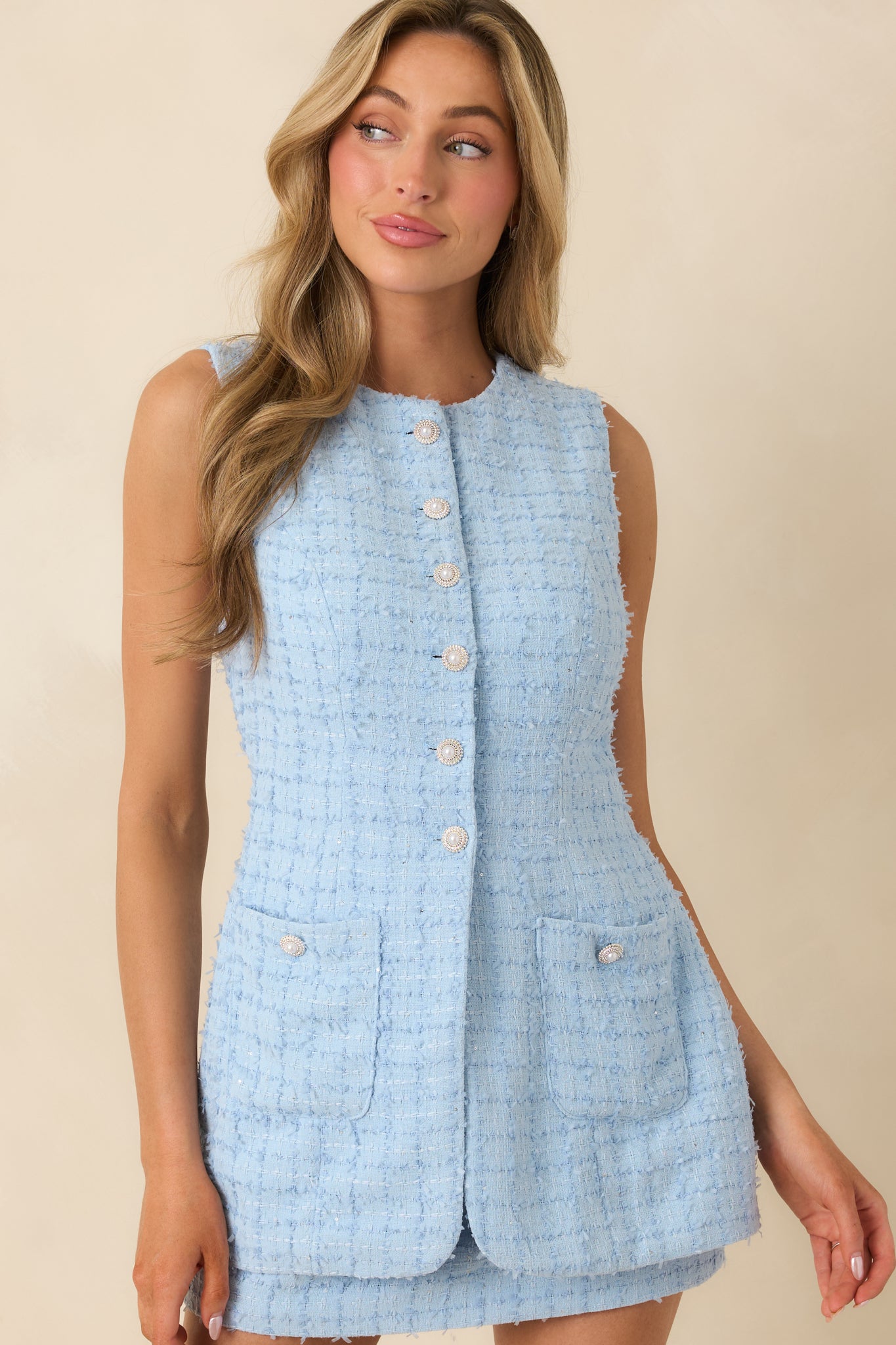 Front pocket detail on light blue textured woven mini dress showing fitted waist seam.