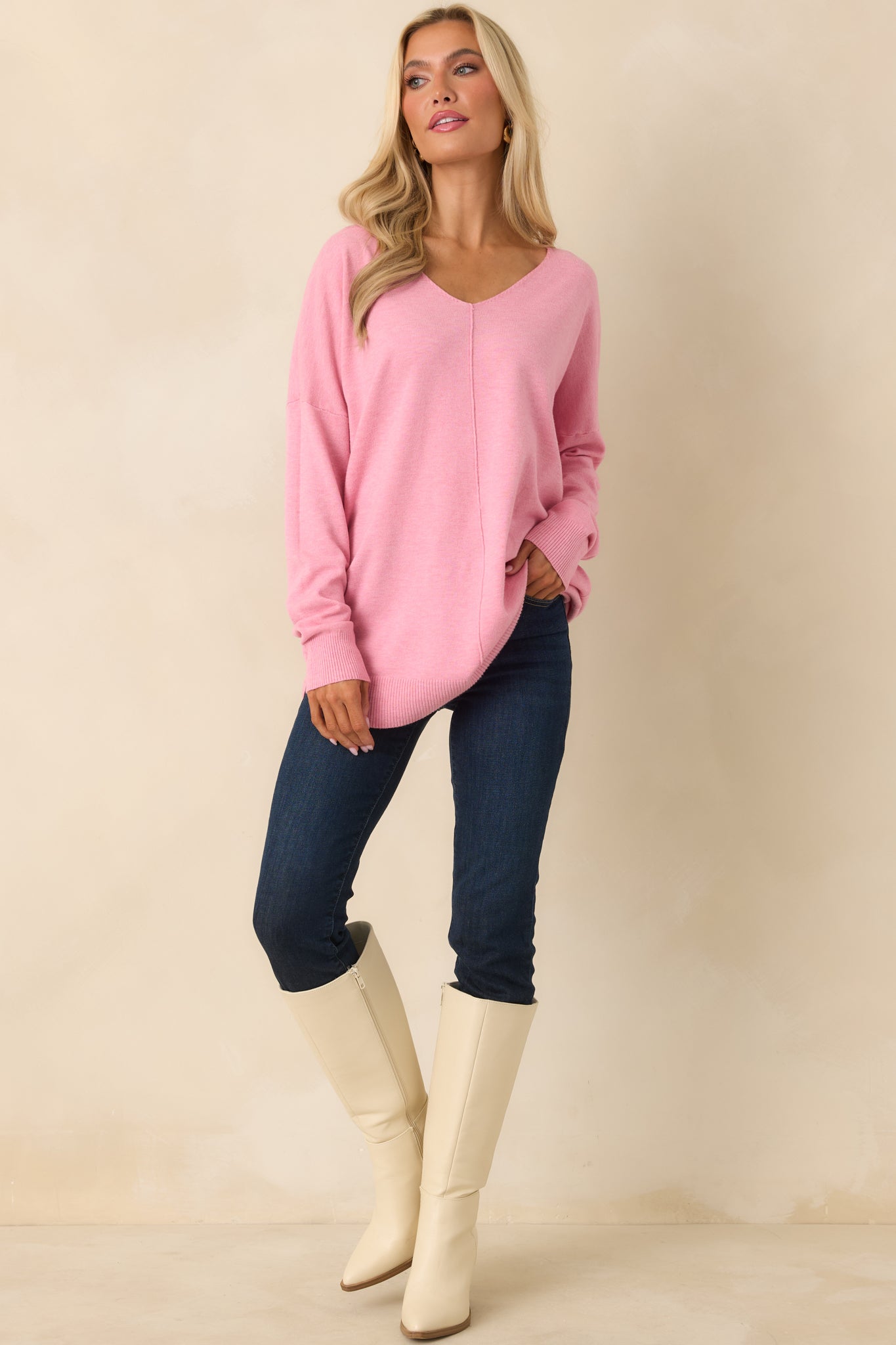 Relaxed bubblegum pink longline sweater with a V-neck and subtle side slits for natural movement.