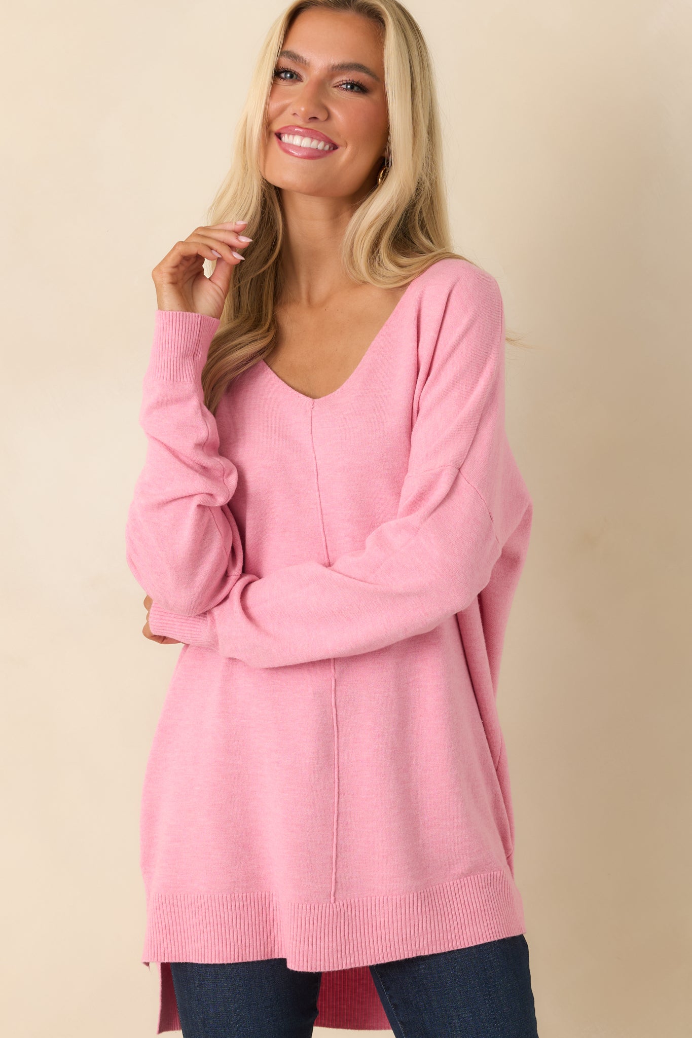Front knit detail of the sweater featuring bubblegum pink stitching with a smooth V-neck border.