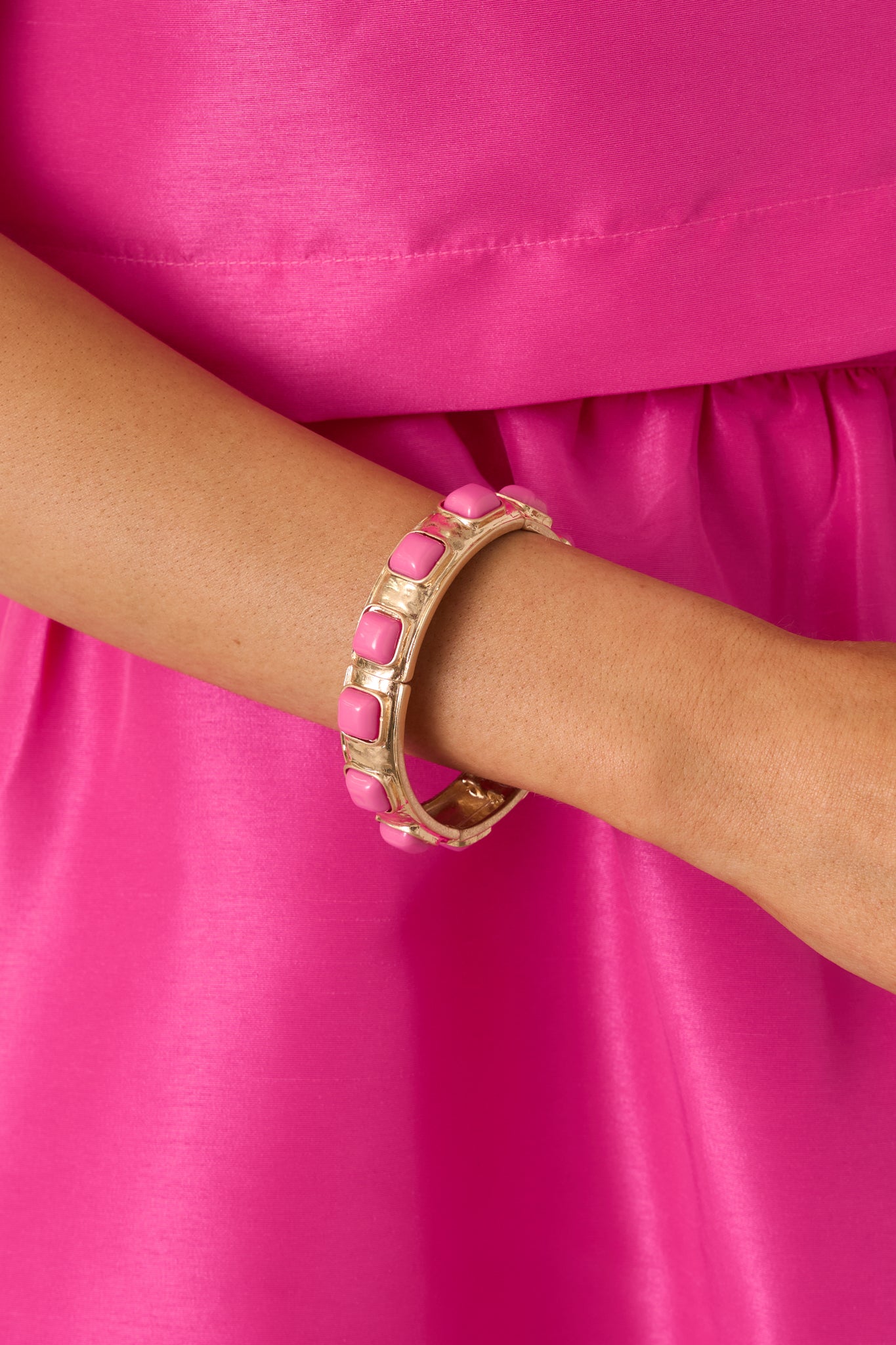 Close view of the pink square cabochons and gold metal setting on the stretch bracelet.
