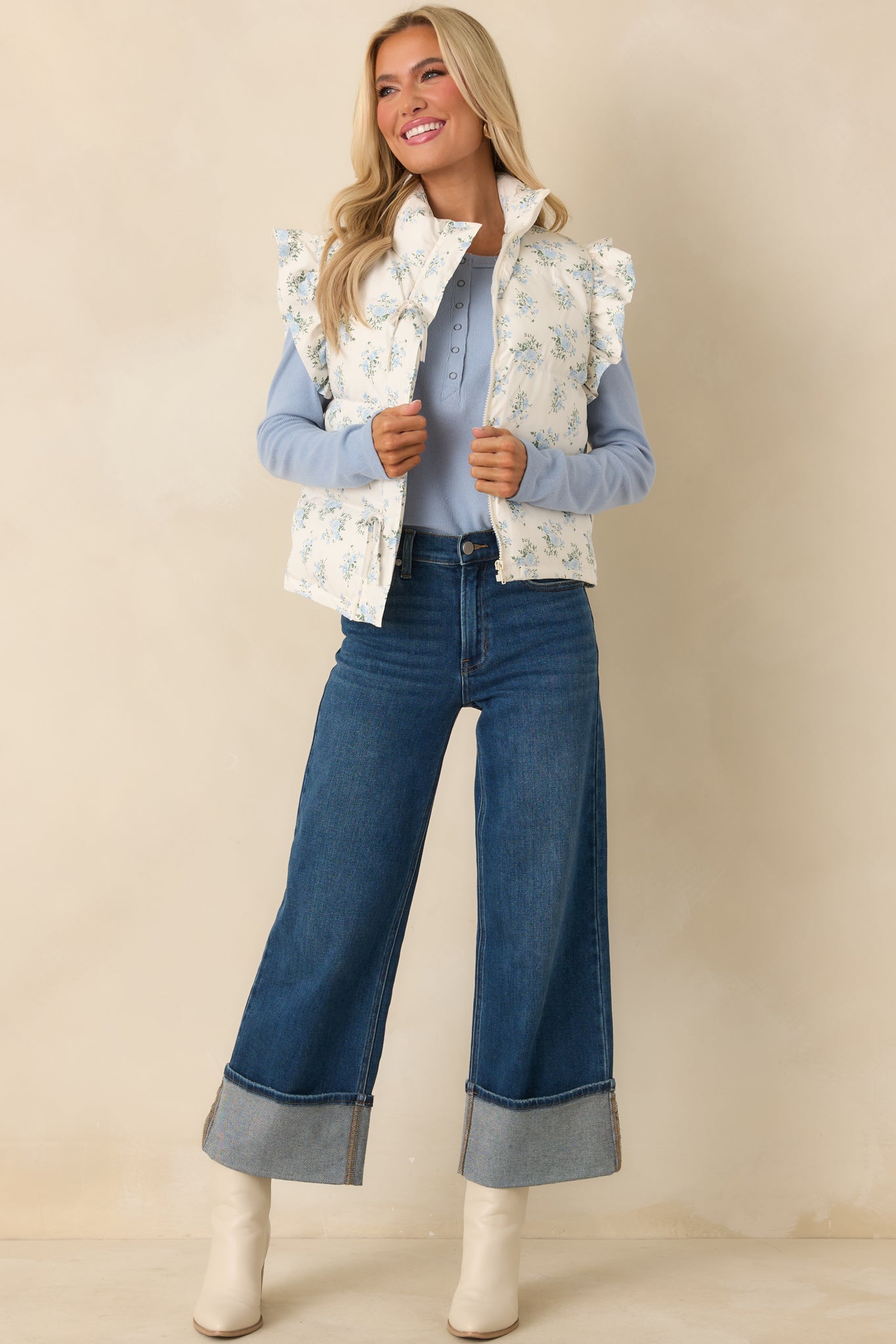 Quilted ivory vest featuring subtle frilled trim at the arm openings, front ties, and a relaxed, lightly padded silhouette.