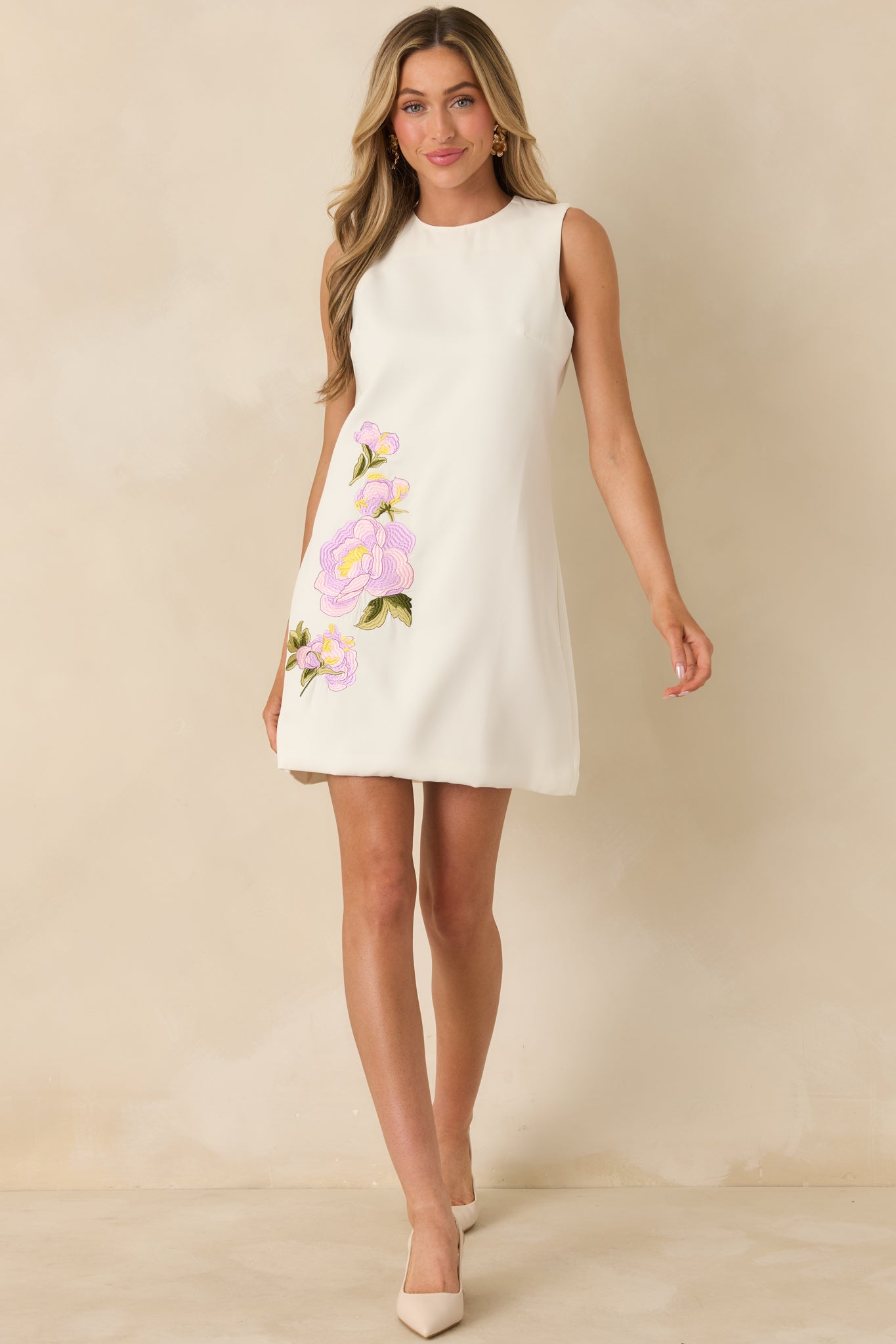 Ivory mini dress with detailed floral embroidery placement and a crisp, structured sleeveless design.