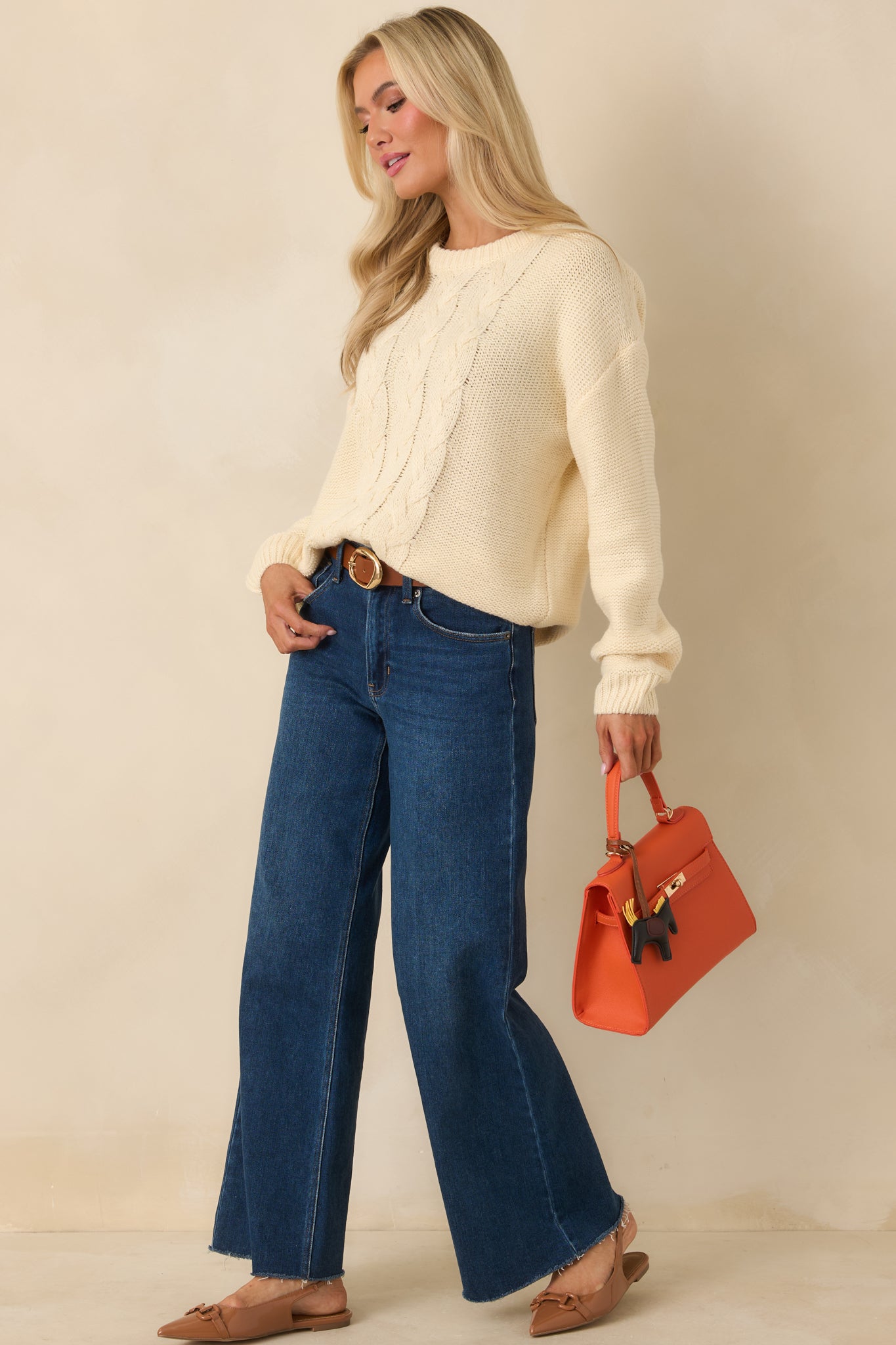 Light ivory pullover highlighting the vertical cable knit design and an easy, comfortable fit for effortless layering.