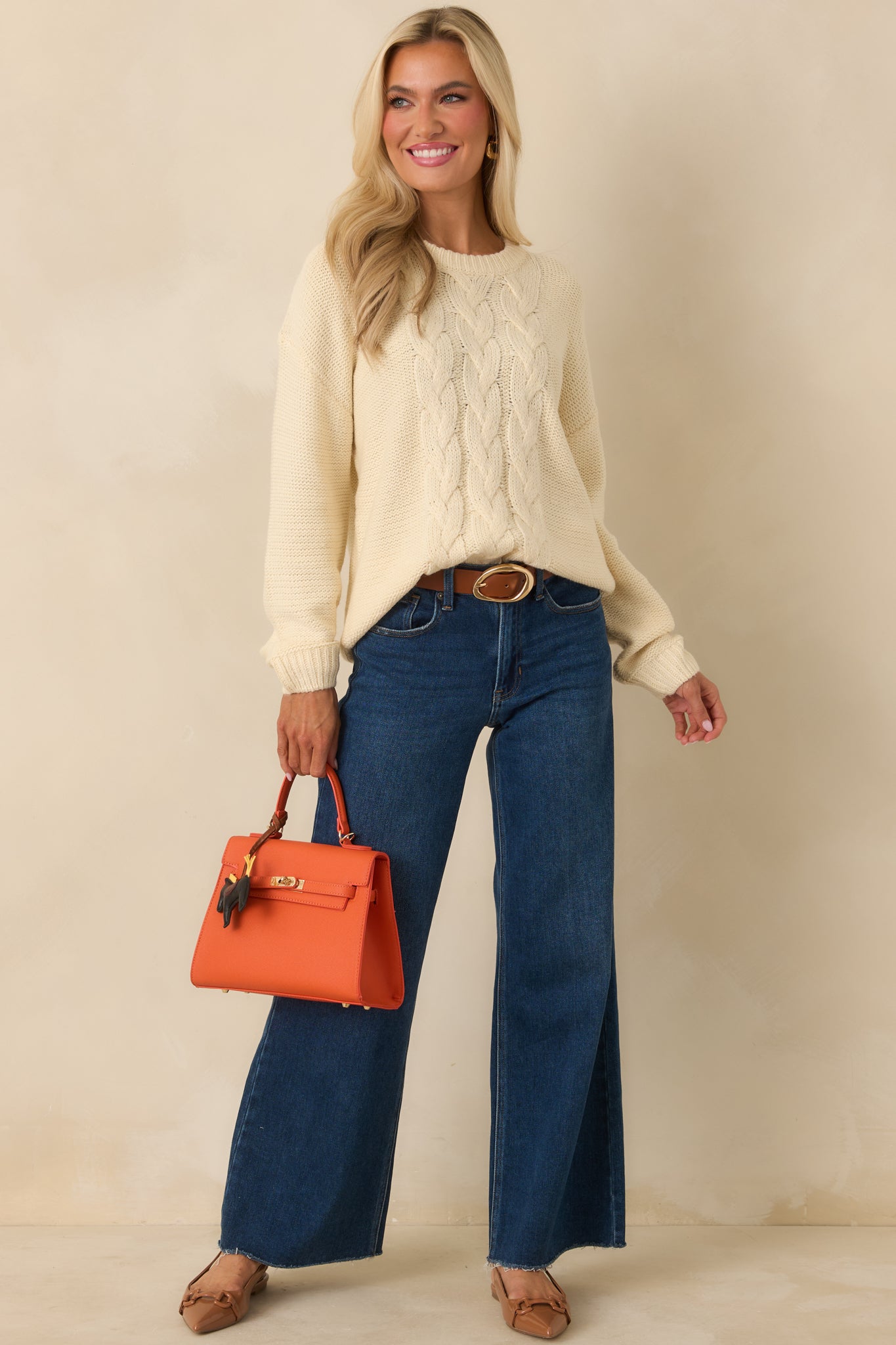 Soft ivory cable-front sweater designed in a breathable knit with relaxed sleeve volume and clean ribbed cuffs.