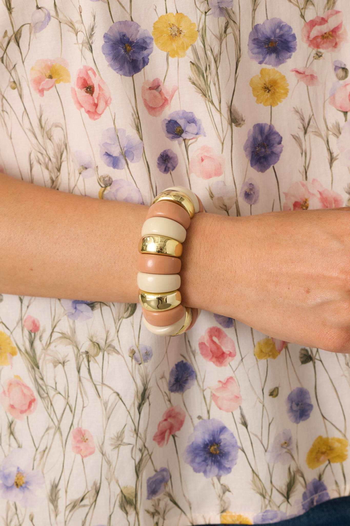 Close view of the blush, ivory, and gold beads showing the smooth surfaces and shine details.