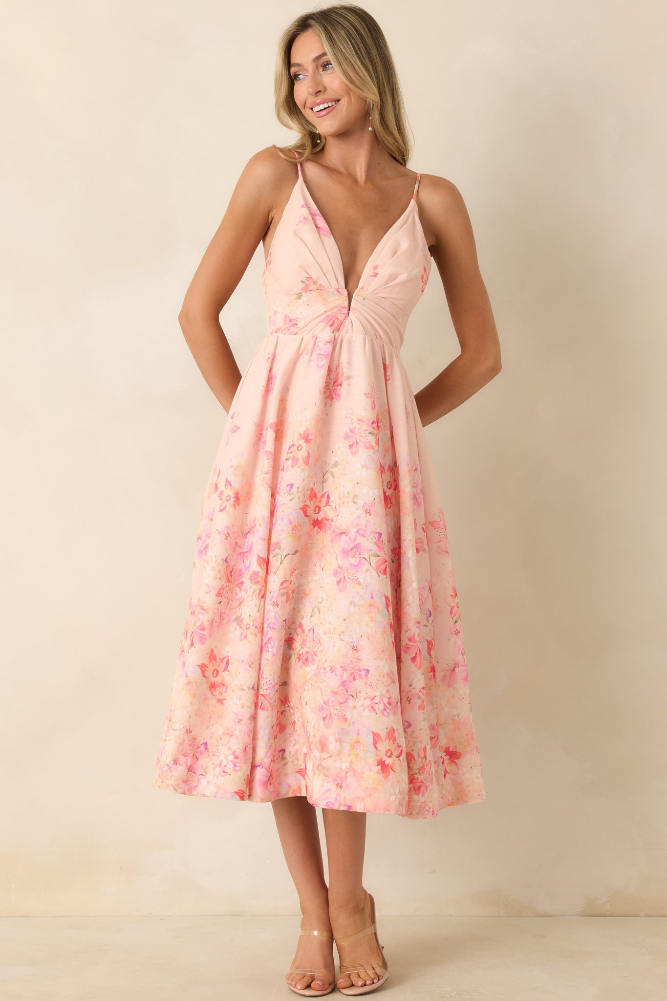 Feminine floral midi dress featuring adjustable straps and a draped, flowy fit through the body.