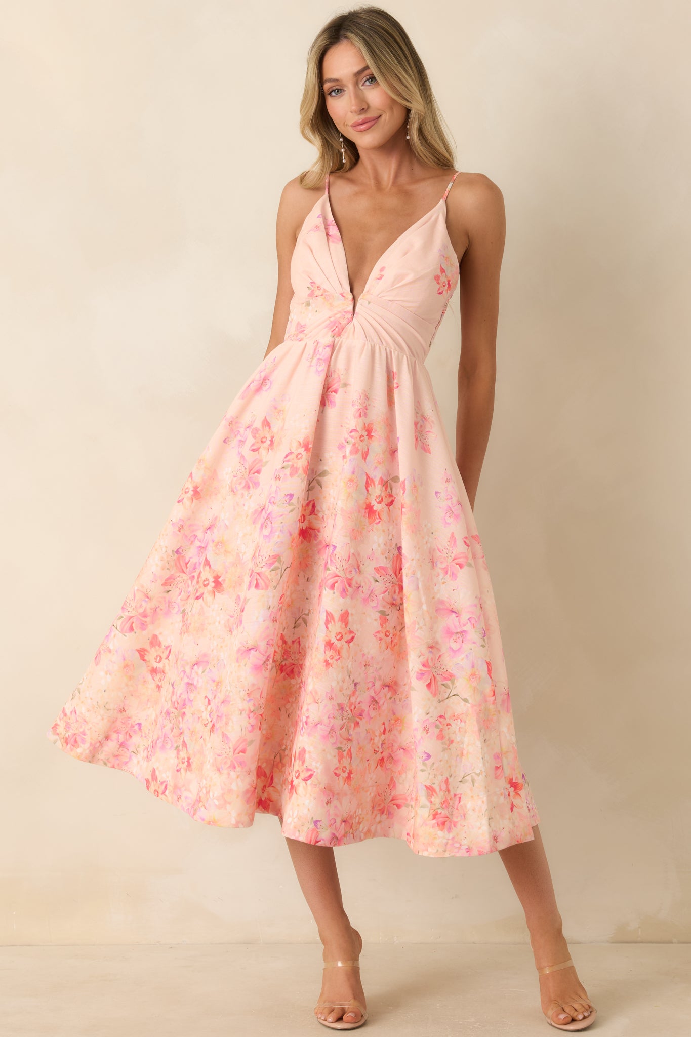Lightweight pink printed dress with a deep V-neckline and effortless midi silhouette designed for movement.