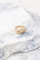Detailed view of ring that features gold hardware and a ribbed design.
