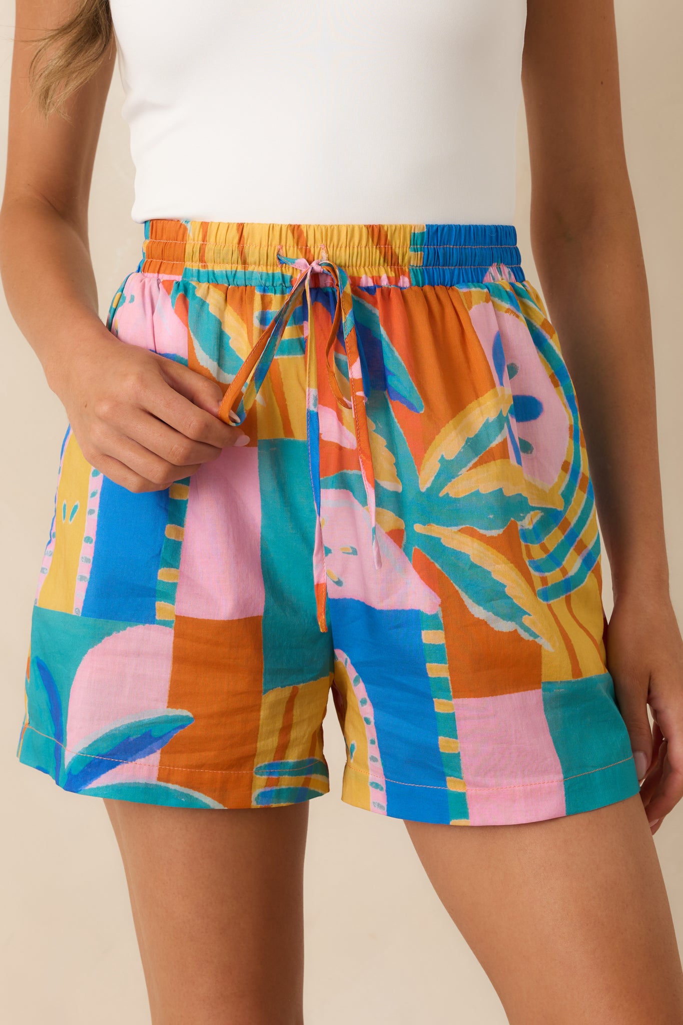 Detailed close-up of the vibrant tropical mosaic print, drawstring waistband, and lightweight cotton fabrication.
