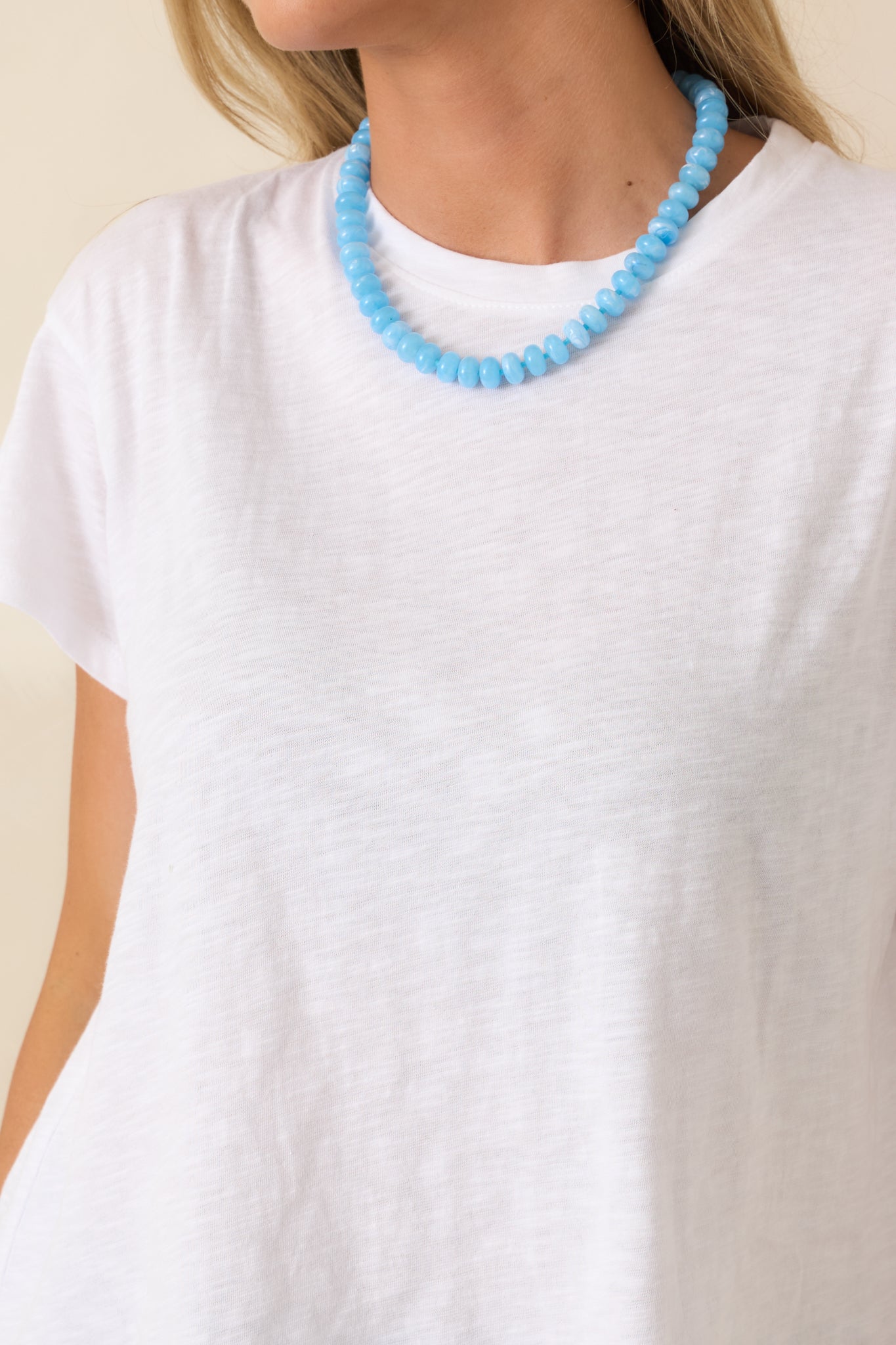 Close-up of white crew neck tee highlighting the modal-cotton blend weave and lightweight texture.