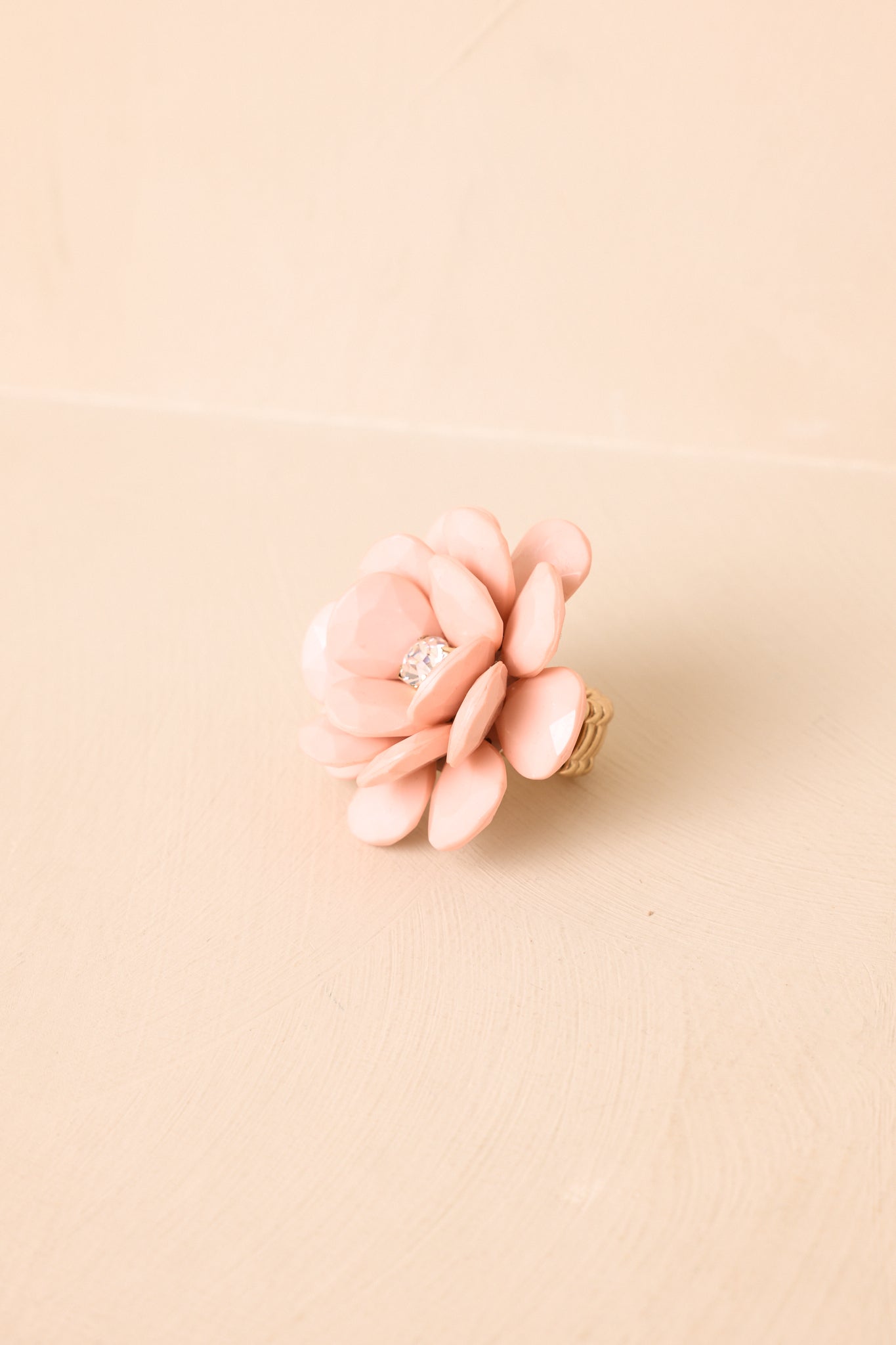 Detailed close-up of pink statement ring highlighting layered petal construction, smooth glossy finish, and sculptural floral form.