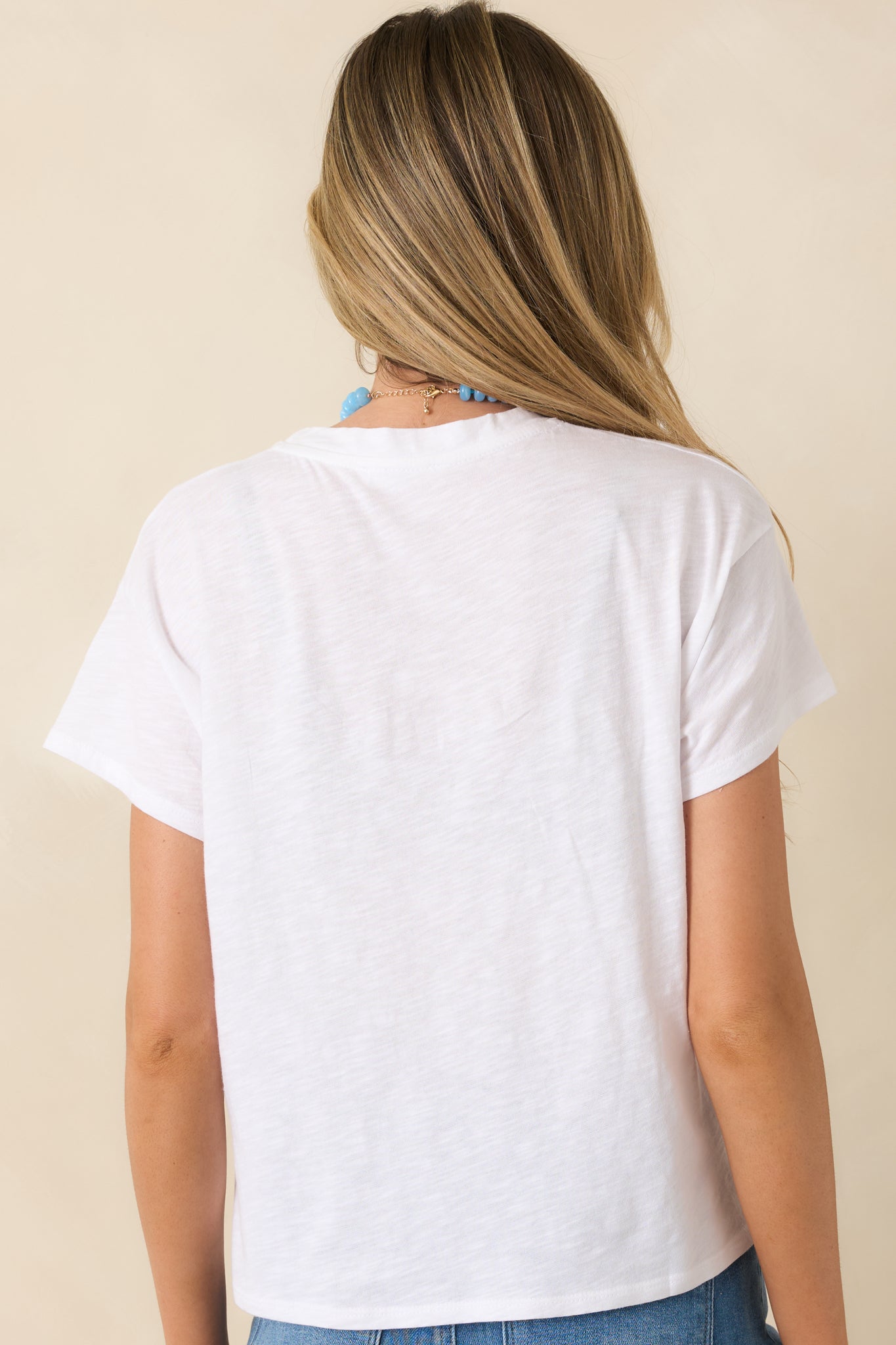 Rear view of white tee showcasing relaxed fit, short sleeves, and clean minimal construction.