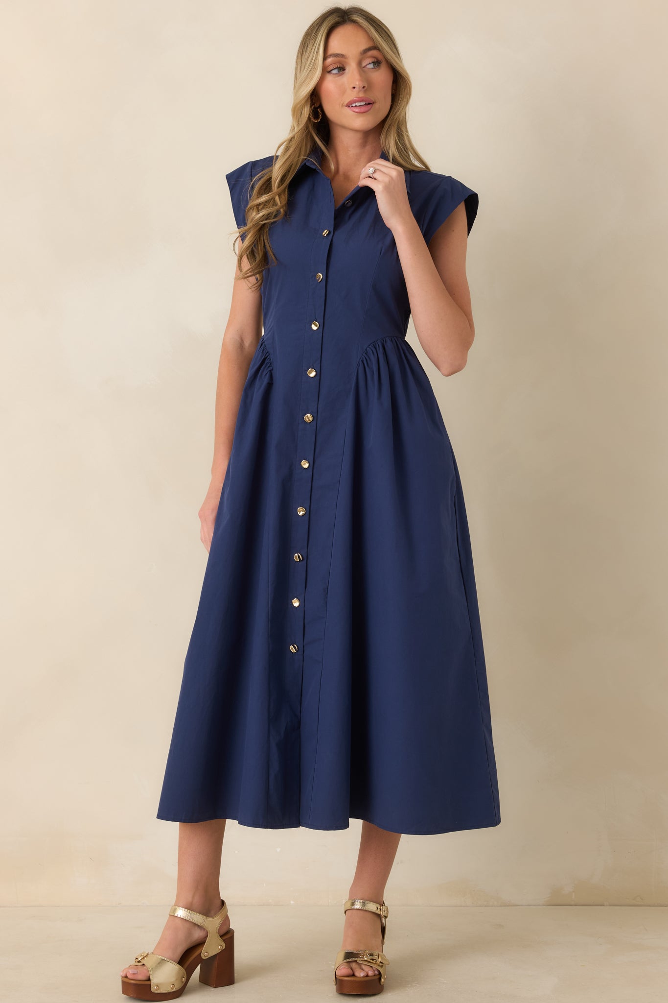 Navy button-front midi dress featuring tailored bodice seams and polished structured fit.