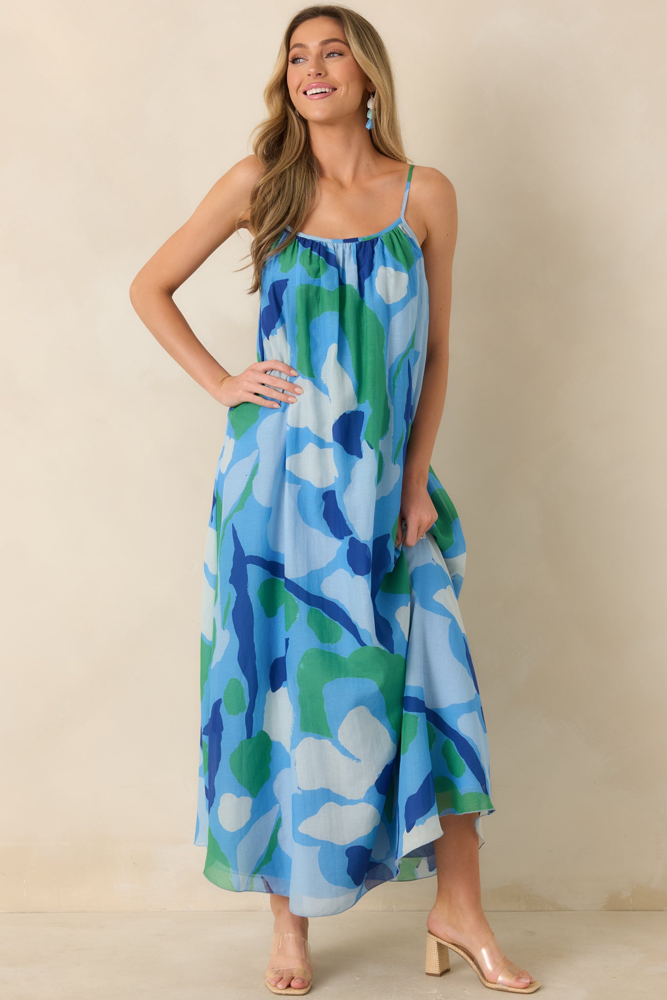 Flowing maxi dress with adjustable straps and abstract botanical pattern.