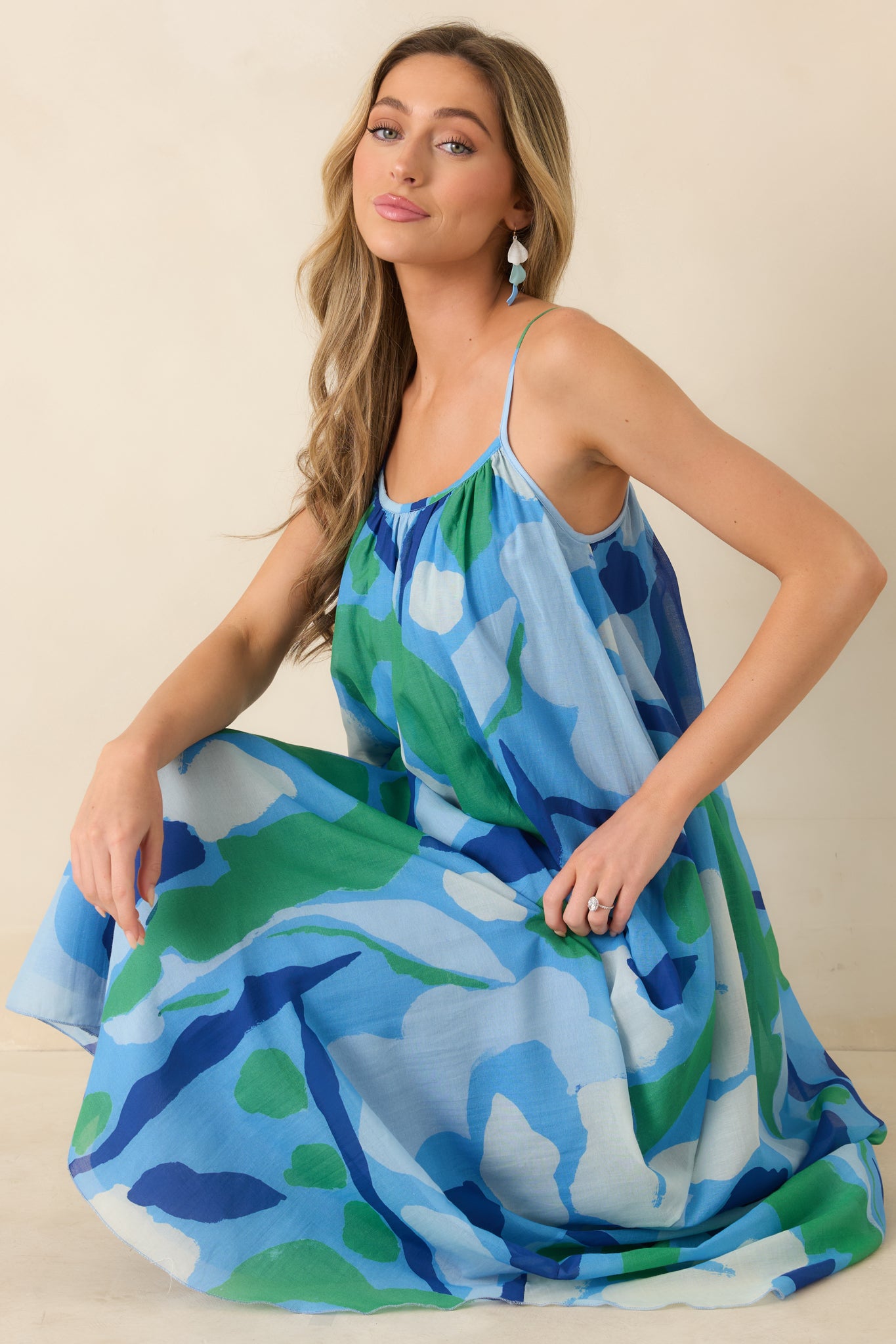 Abstract blue and green floral maxi dress with flowy silhouette and thin straps.