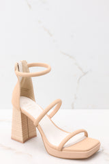 These beige heels feature a square toe, two straps across the top of the foot with one around the ankle, as well as a block heel and a zipper at the back of the ankle.