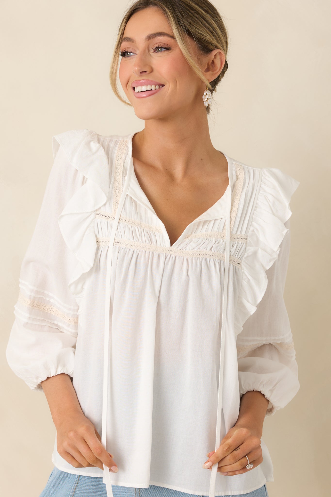 Cropped view of ruffle-trimmed shoulders and soft woven fabric texture.