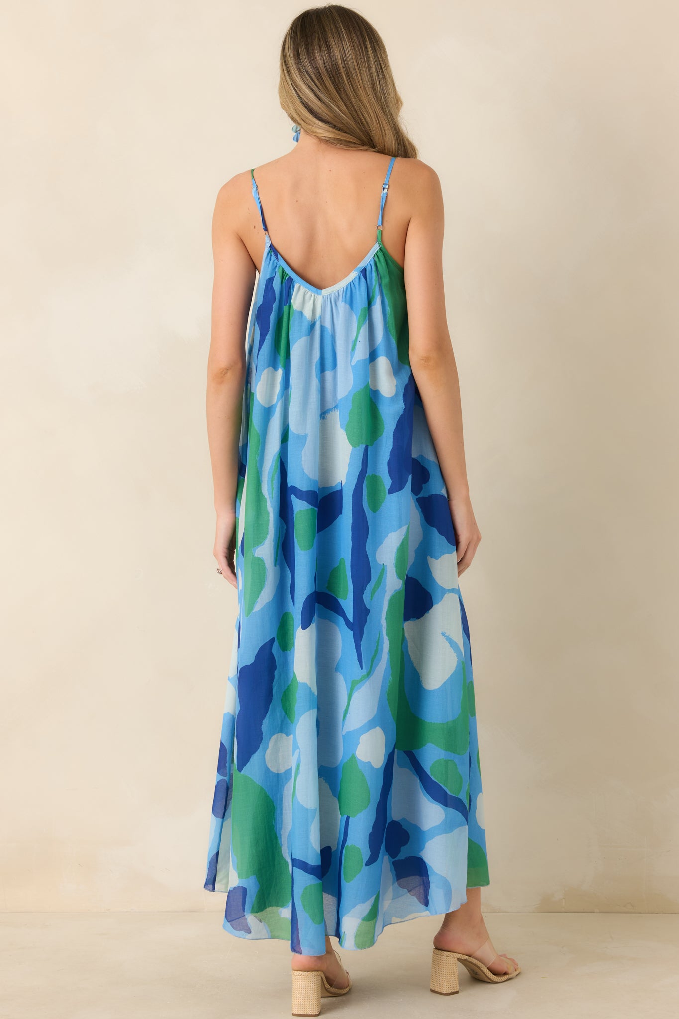 Rear view of floral maxi dress with open back detail and thin adjustable straps.

