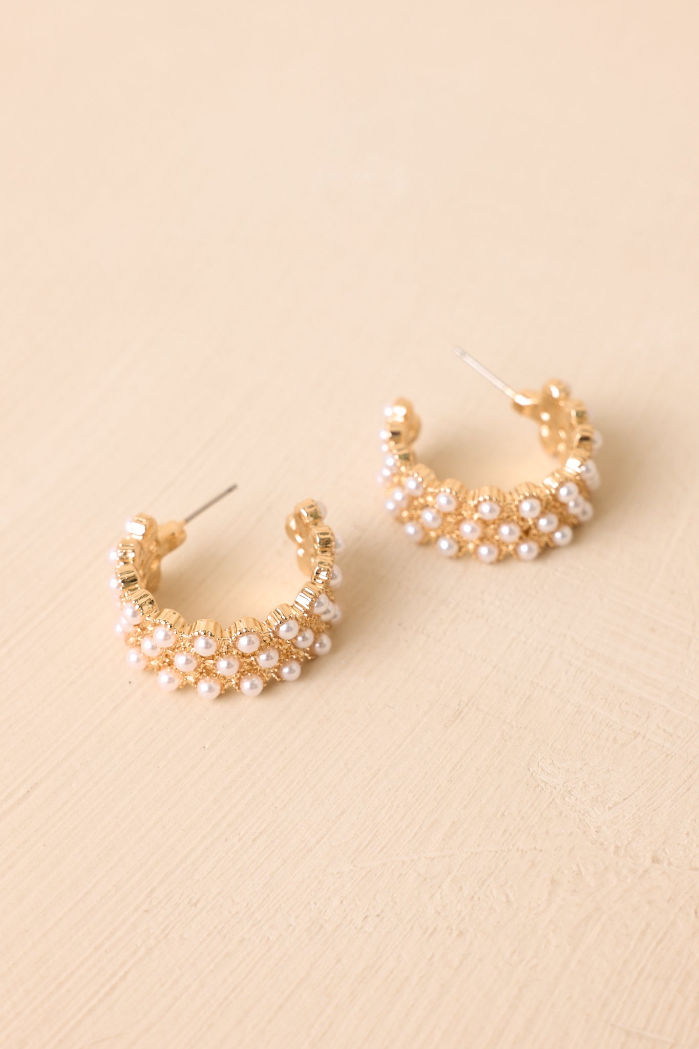 Elegant gold-tone hoops detailed with petite faux pearls throughout the design, creating a classic and versatile accessory.