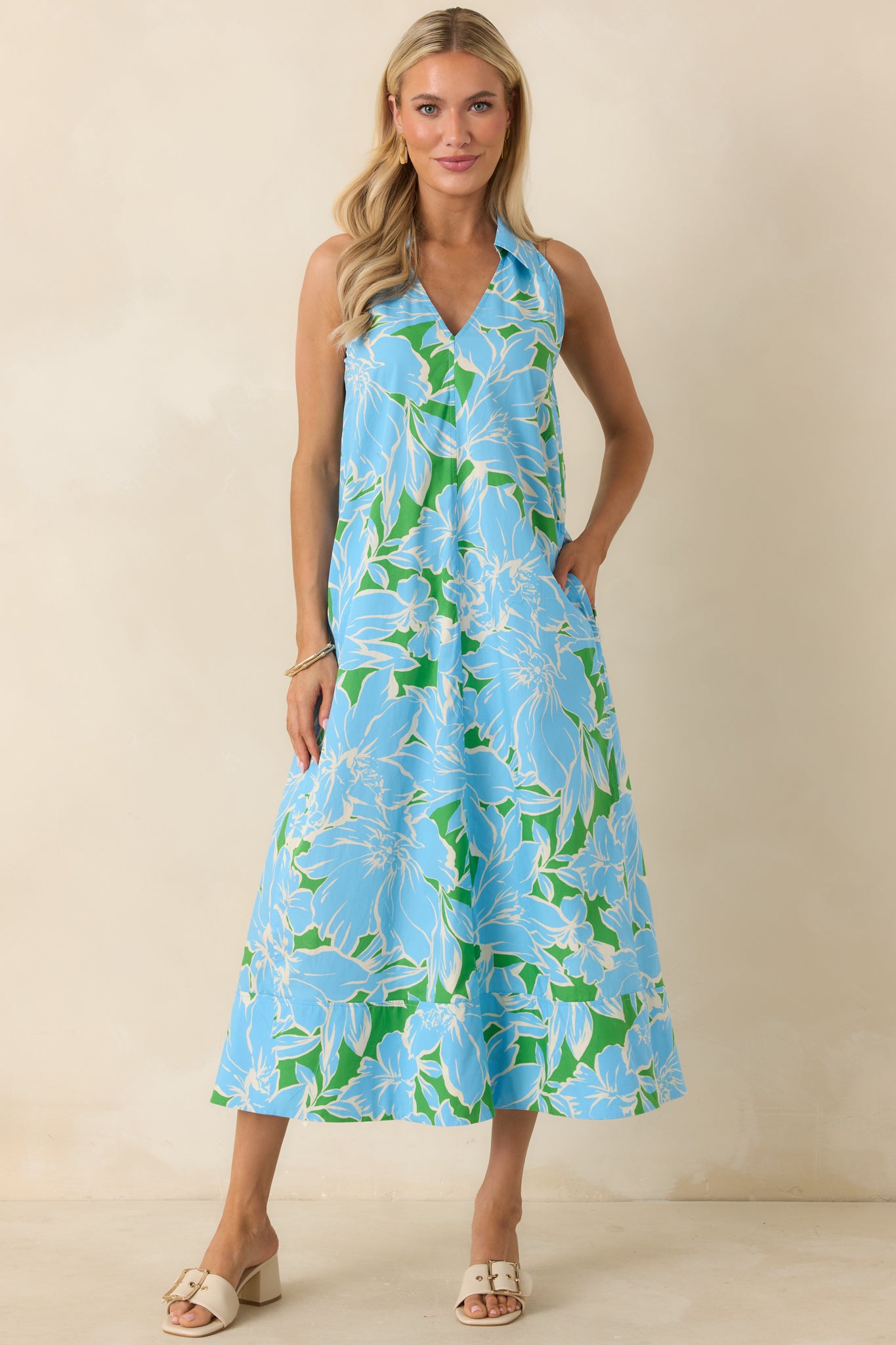 Sleeveless floral midi dress with a collared neckline, relaxed shape, side pockets, and a full skirt in lightweight cotton.