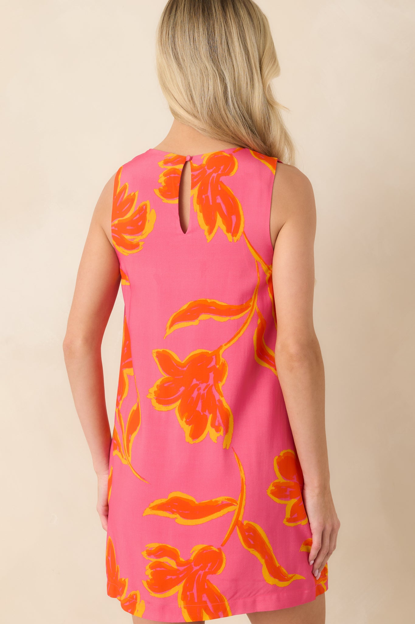 Rear view of printed mini dress featuring relaxed shift fit and subtle keyhole closure at neckline.

