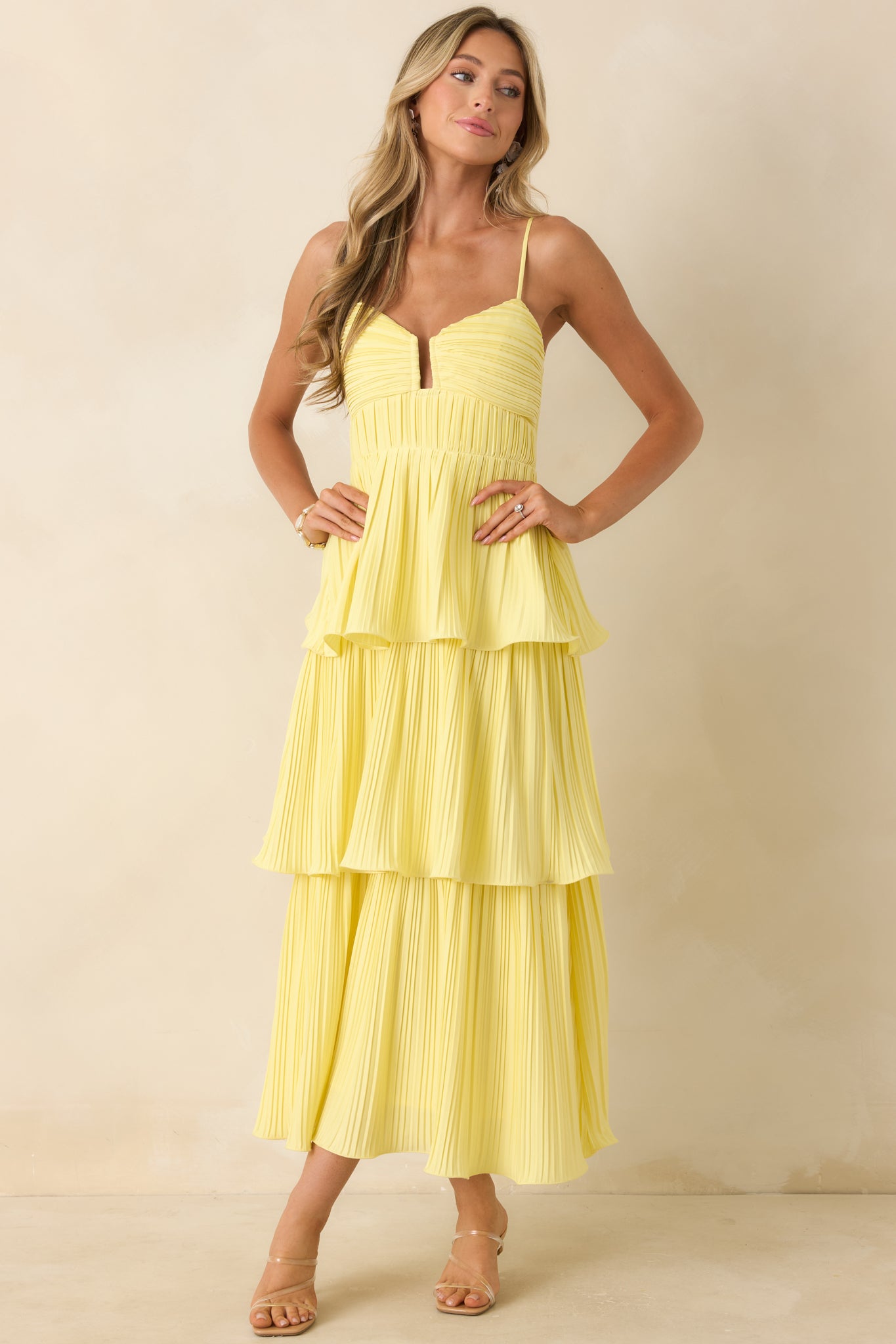 Maxi dress in yellow with a fitted upper bodice and softly structured pleating throughout the design.