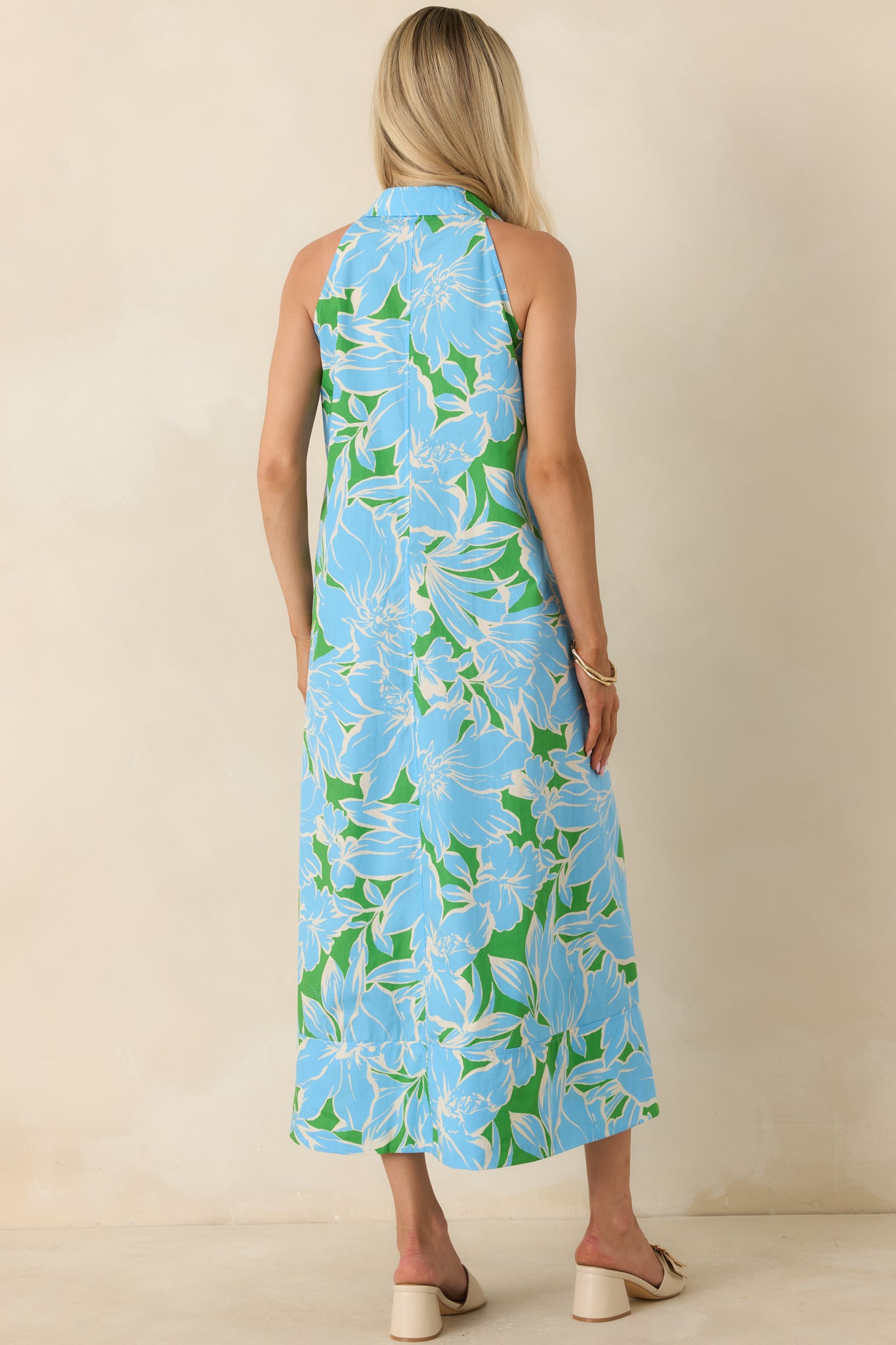 Rear view of the floral cotton midi dress featuring a sleeveless silhouette, relaxed fit, and flowing midi-length skirt.