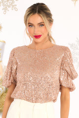 Front view of this top that features a round neckline, a keyhole opening on the back, puff sleeves with elastic cuffs, and sequins throughout.