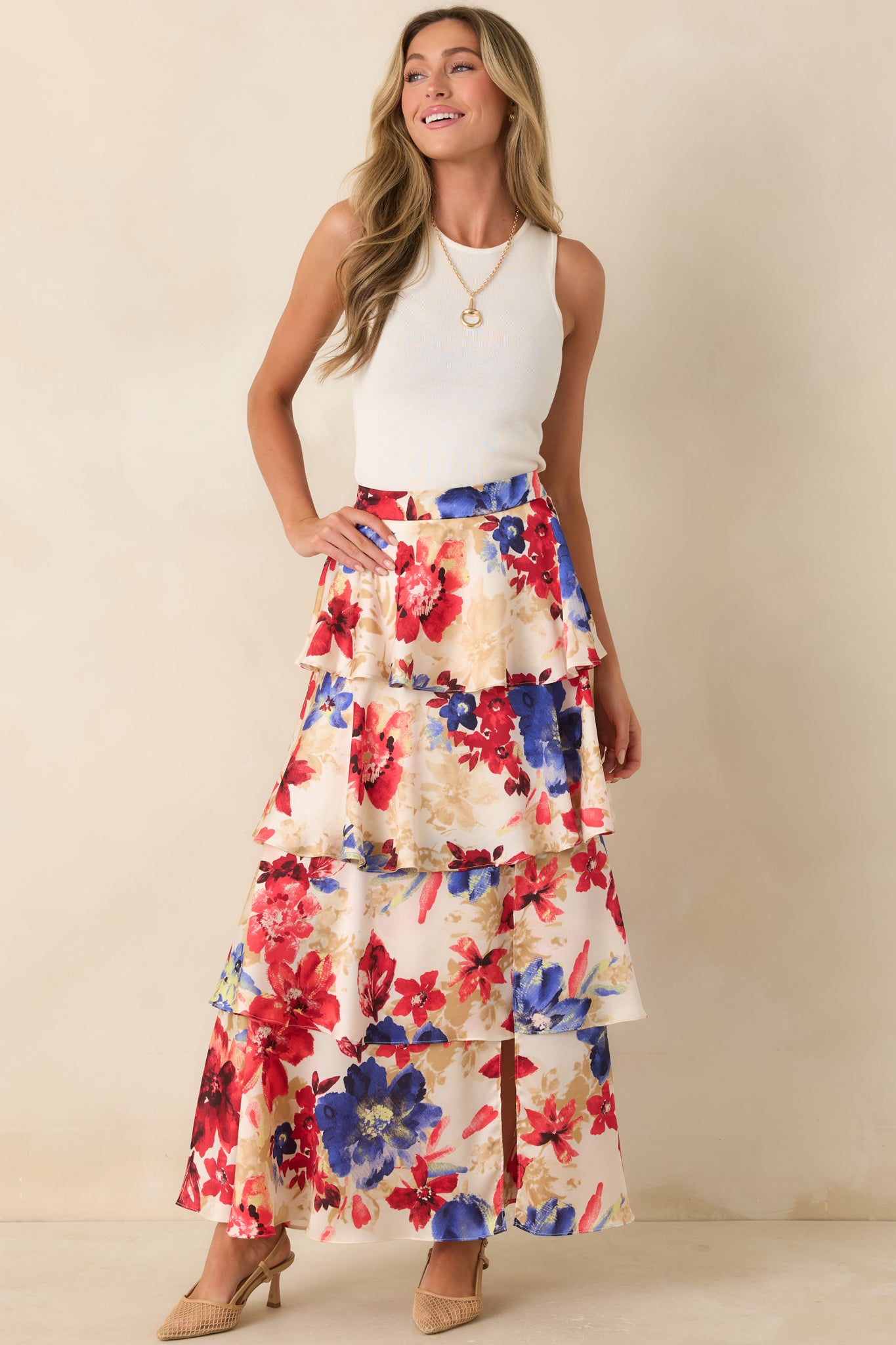 Tiered maxi skirt featuring a vibrant red floral pattern on an ivory base with soft volume.