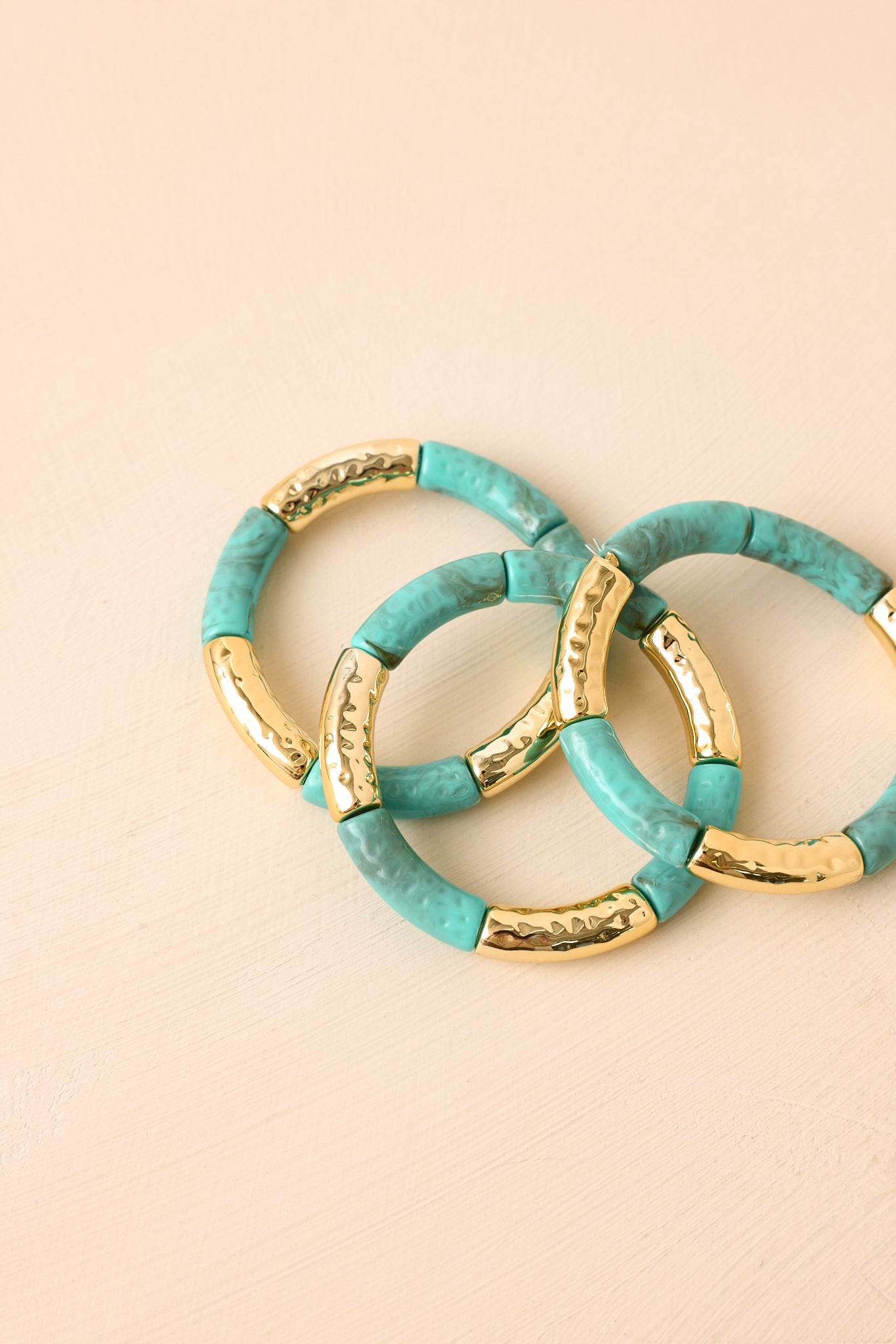 Close-up of the bracelets showcasing the textured turquoise beads, elongated gold-tone accents, and intricate detailing.