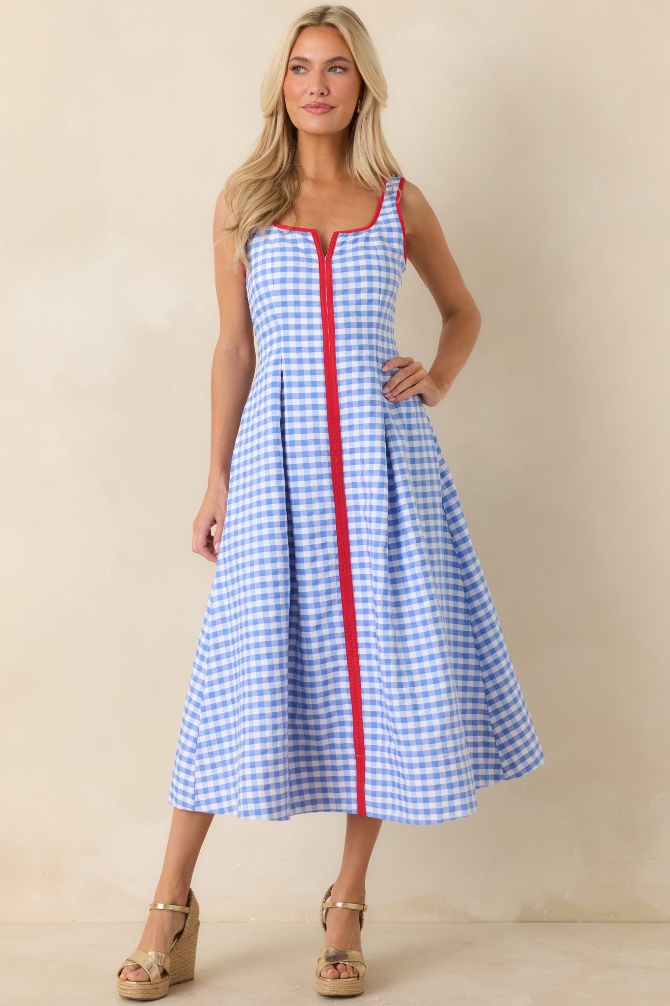 Gingham midi dress with fitted bodice, pleated skirt detailing, and structured waist shaping.