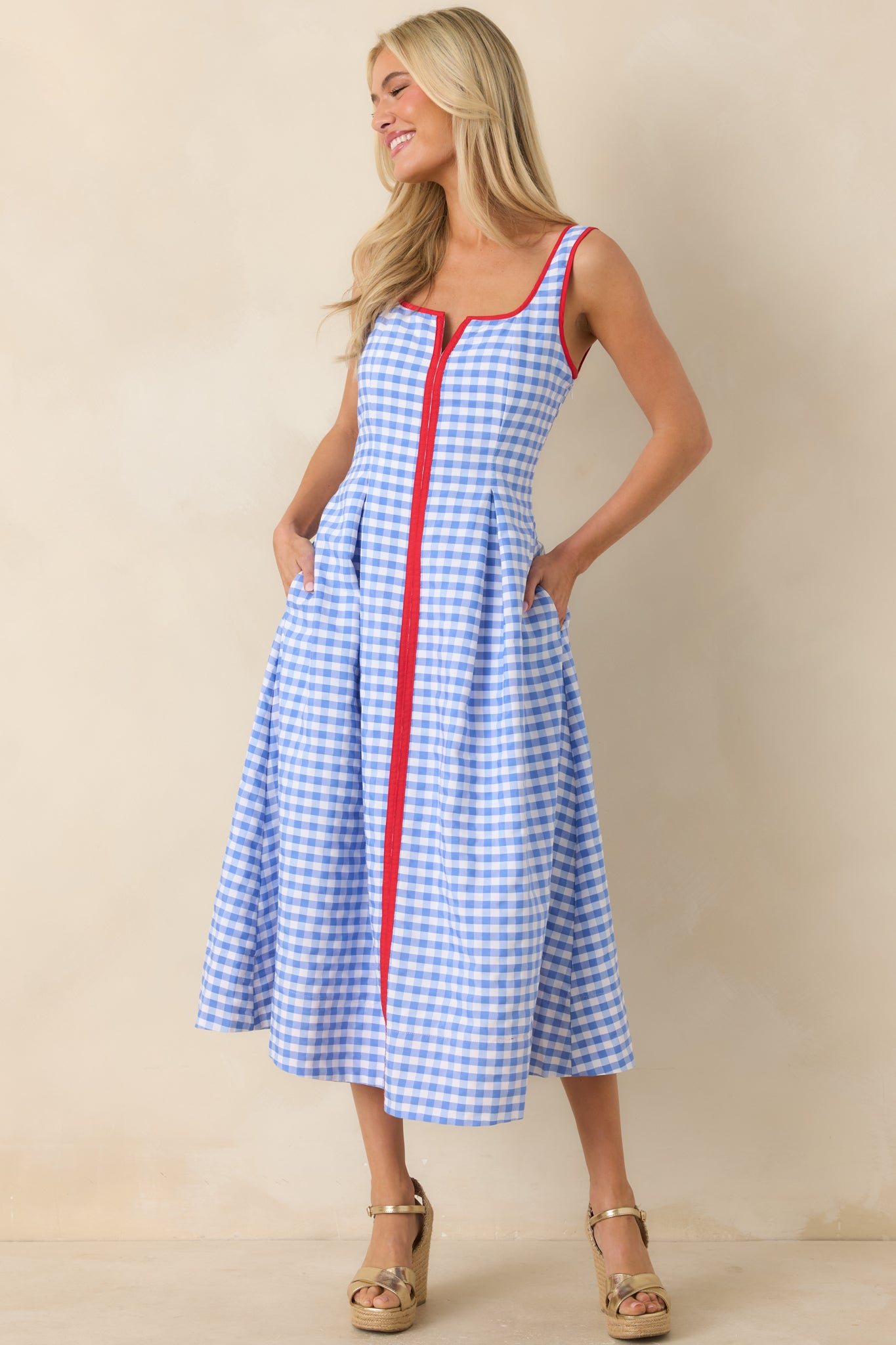 Midi dress with notched neckline detail, side pockets, and softly pleated skirt construction.