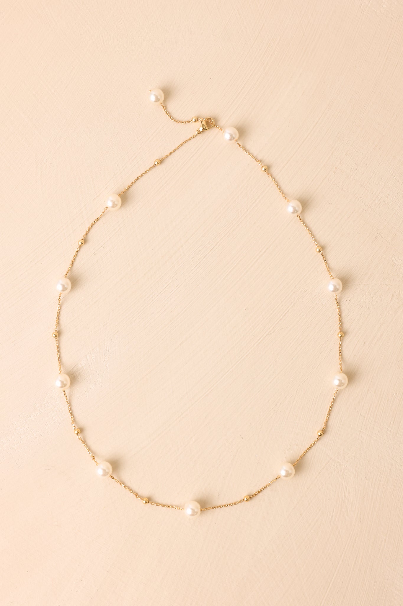 Delicate gold necklace with faux pearl accents throughout the chain, creating a timeless and versatile design.