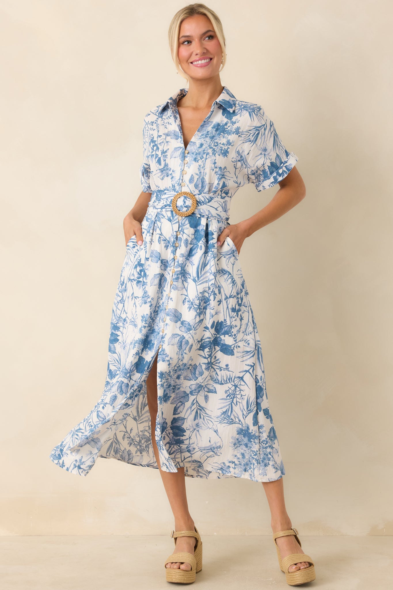 A blue midi dress, highlighting the collared V-neckline, button-down front, and waist-cinching pull-through belt.