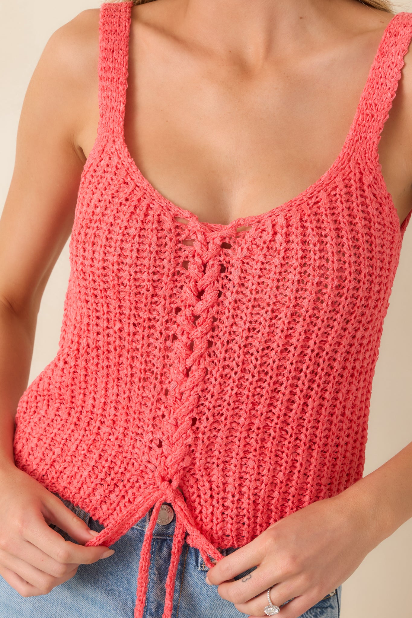 Close-up of lace-up front detail on coral textured knit tank.
