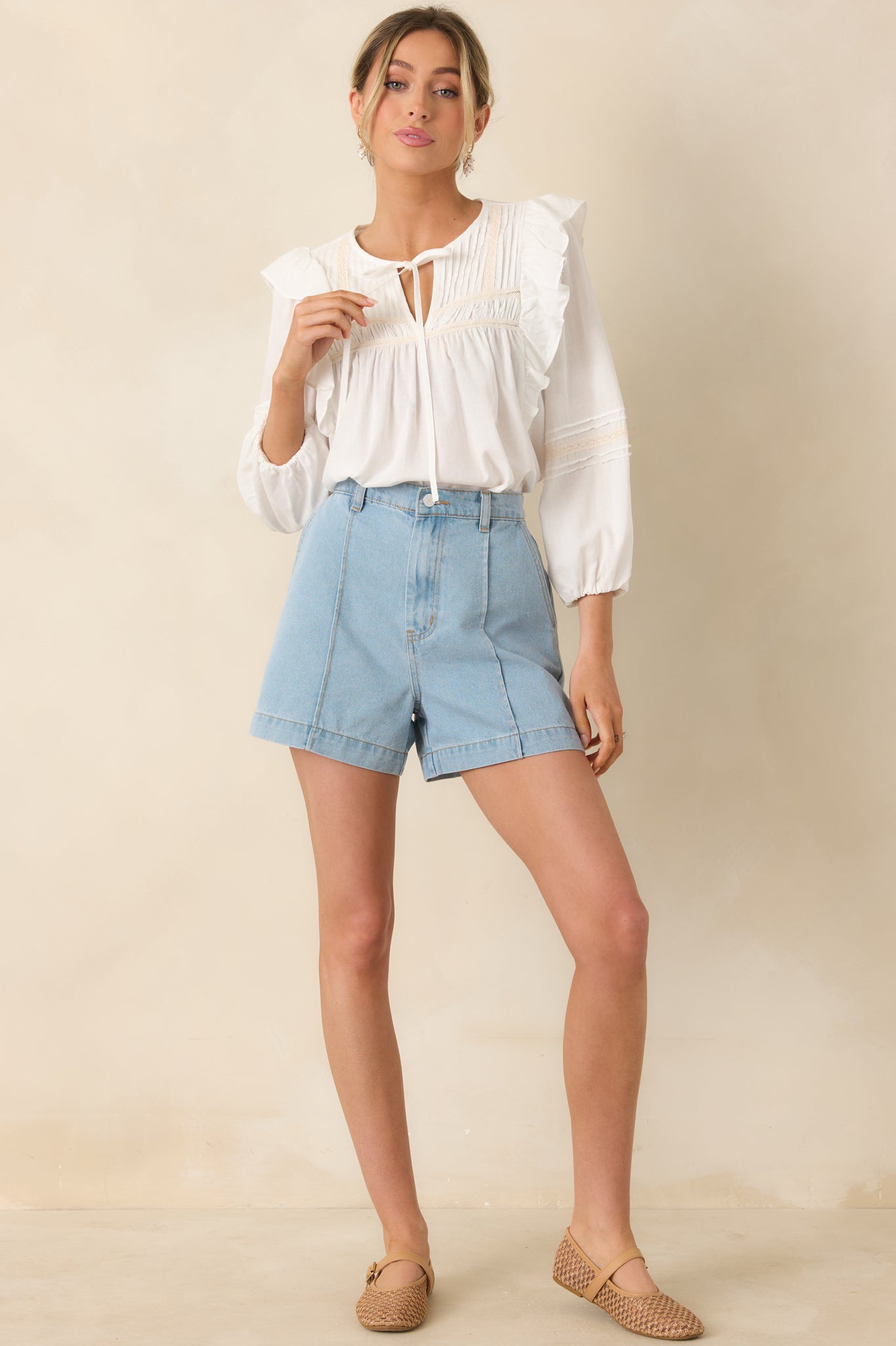 White flowy blouse with V-neckline, lace inset detailing, and relaxed silhouette.