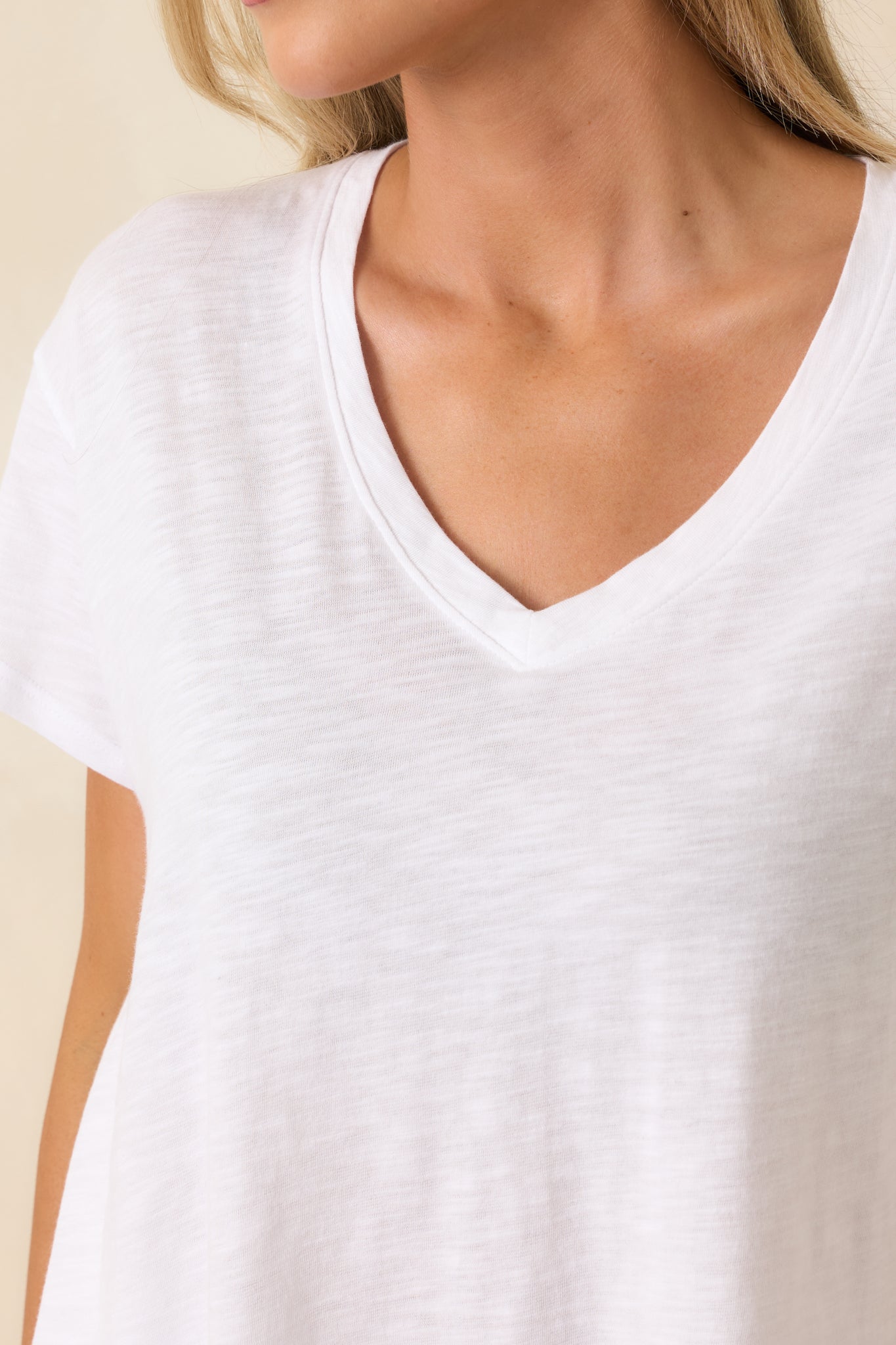 Close-up of white v-neck tee highlighting modal-cotton blend texture and lightweight breathable weave.