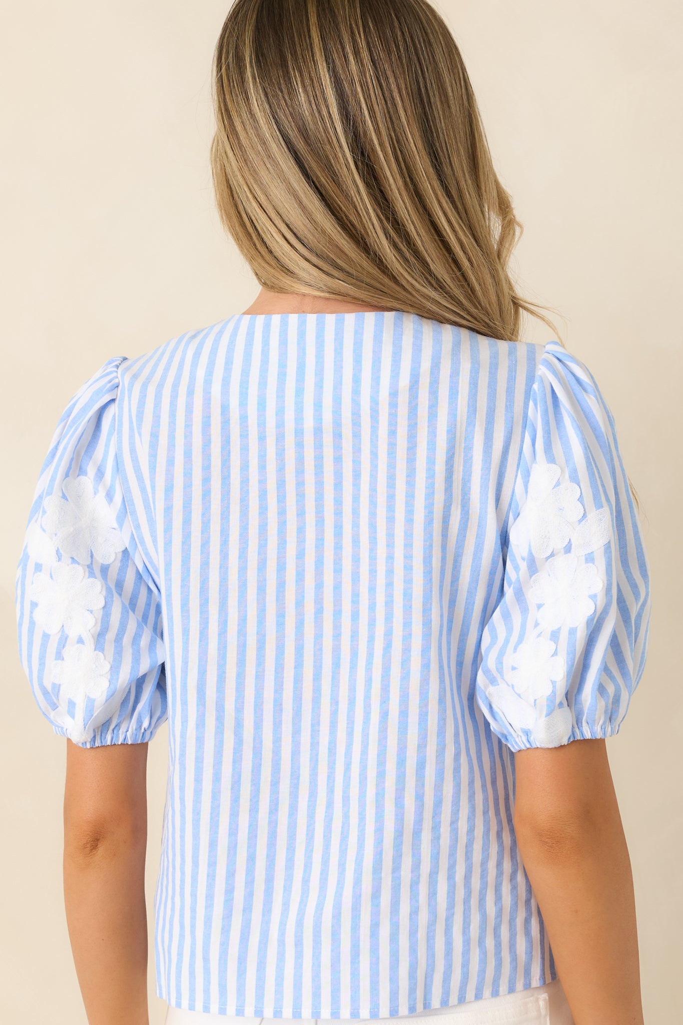 Rear view of relaxed blouse featuring smooth lightweight fabric and clean finished back.

