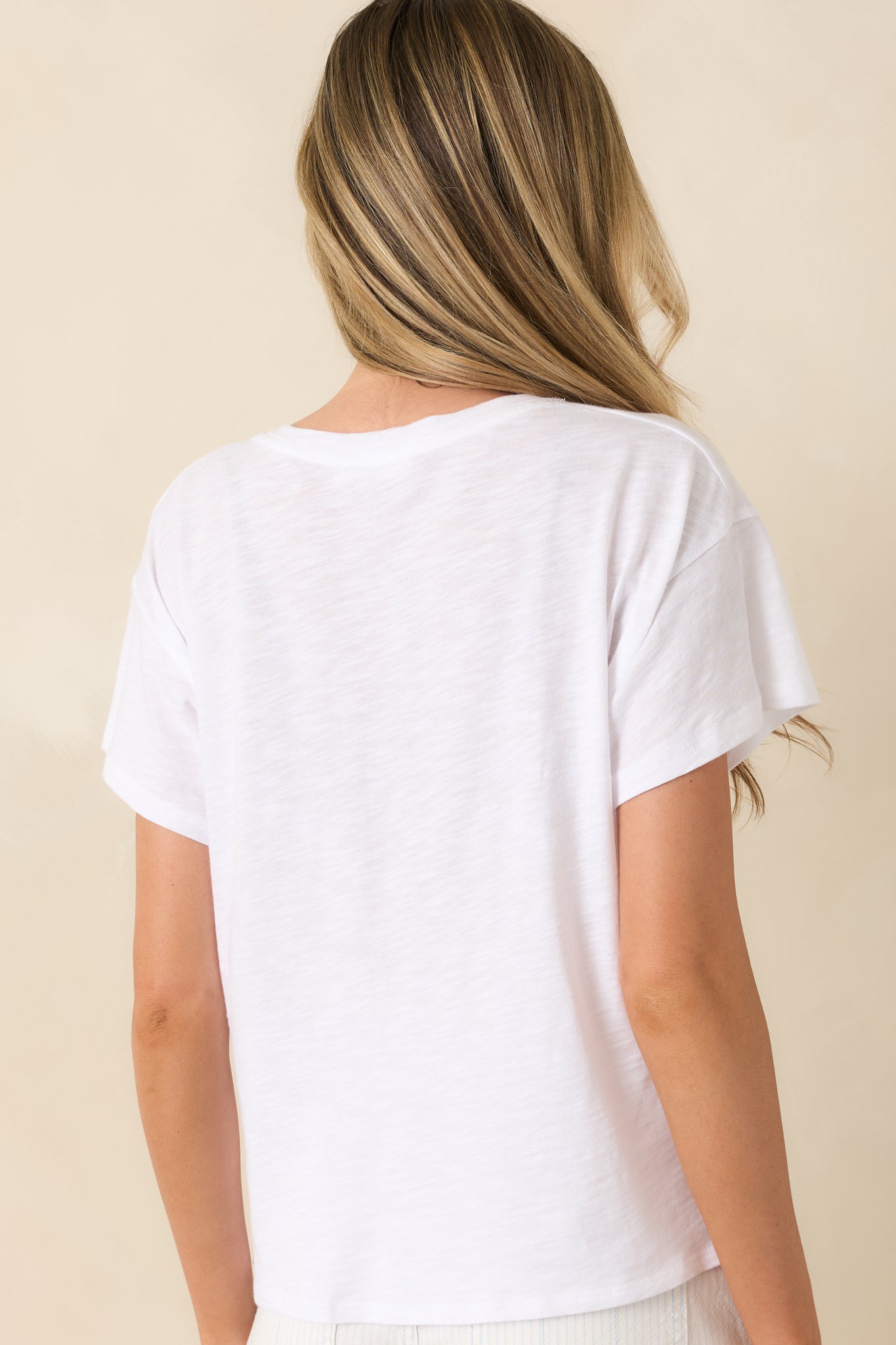 Rear view of white tee showcasing relaxed fit, short sleeves, and clean minimal construction.