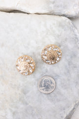 Overhead close up view of gold textured stud earrings that measure approximately 1